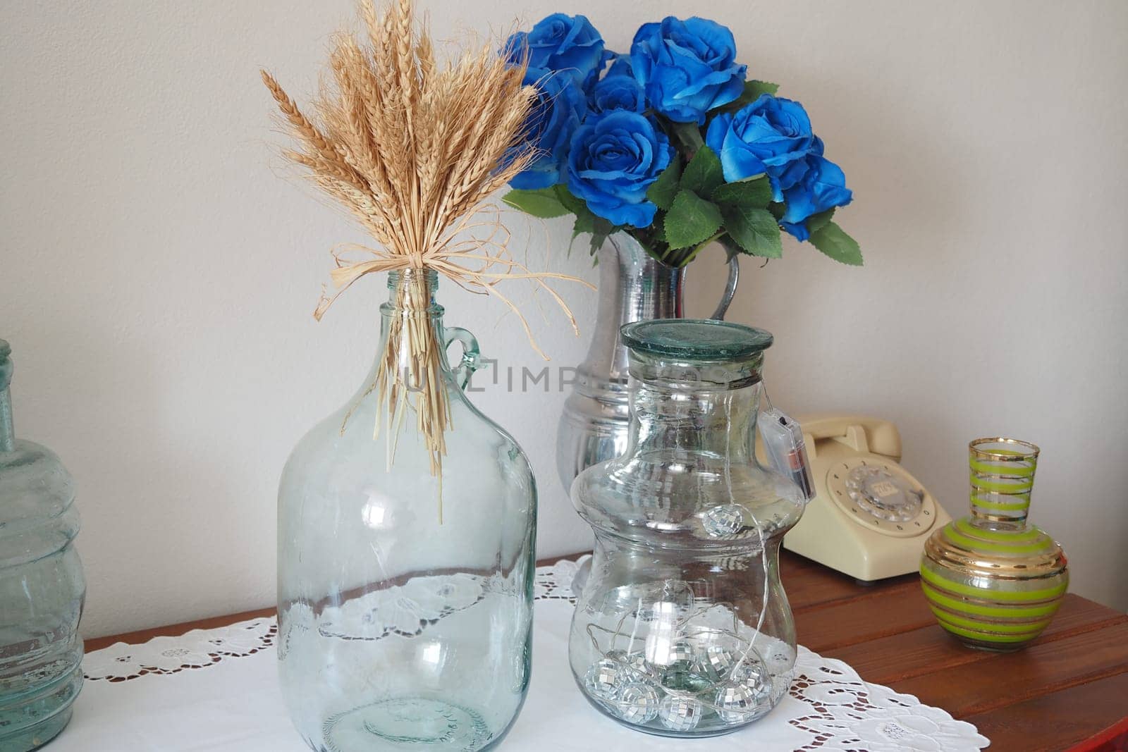 Beautifully arranged glass bottles and faux flowers enhance home decor.