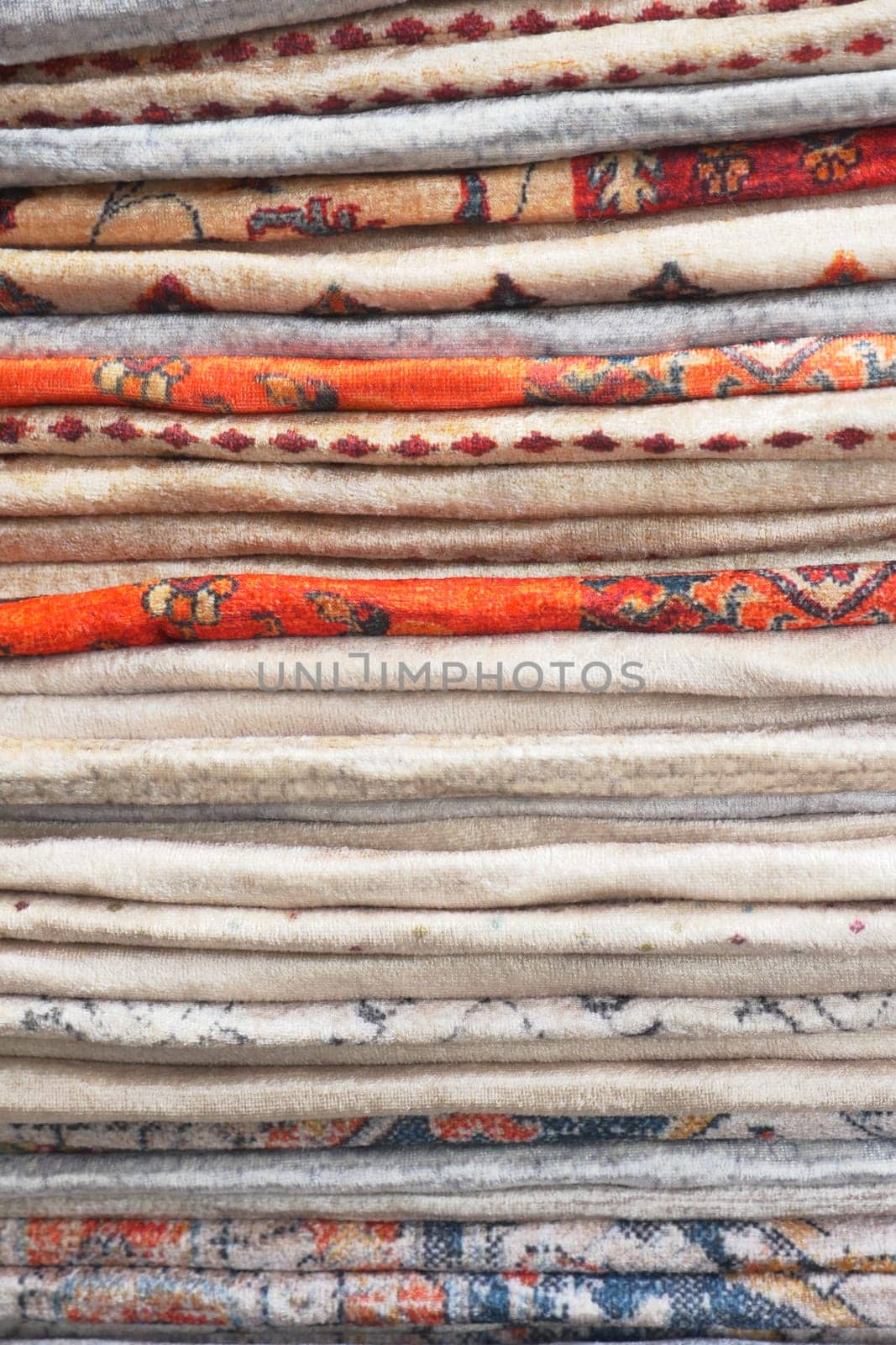 Colorful rug stacked in intricate patterns at a local market,
