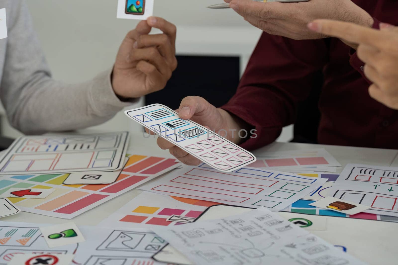 Design team members interactively exchange design ideas and refine sketch prototypes, enhancing their UX UI workflows.
