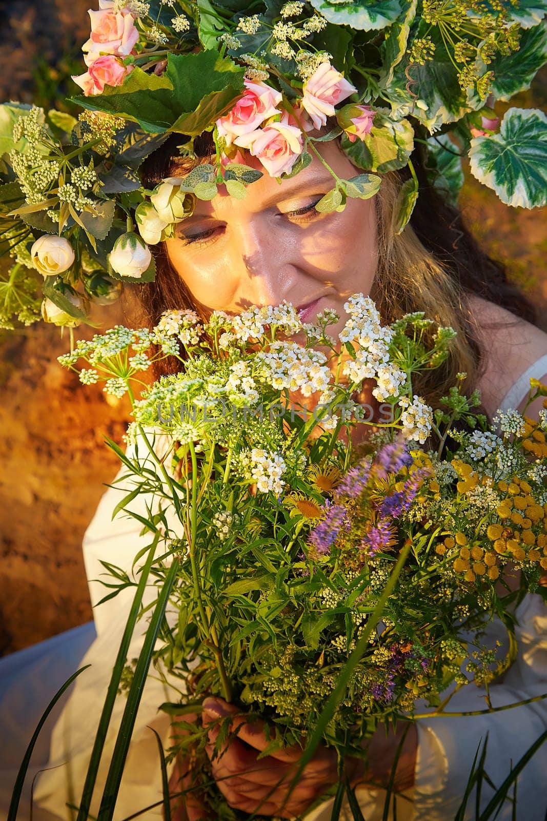 Slavic plump chubby girl in long white dress on the feast of Ivan Kupala with flowers and water in a river or lake on summer evening