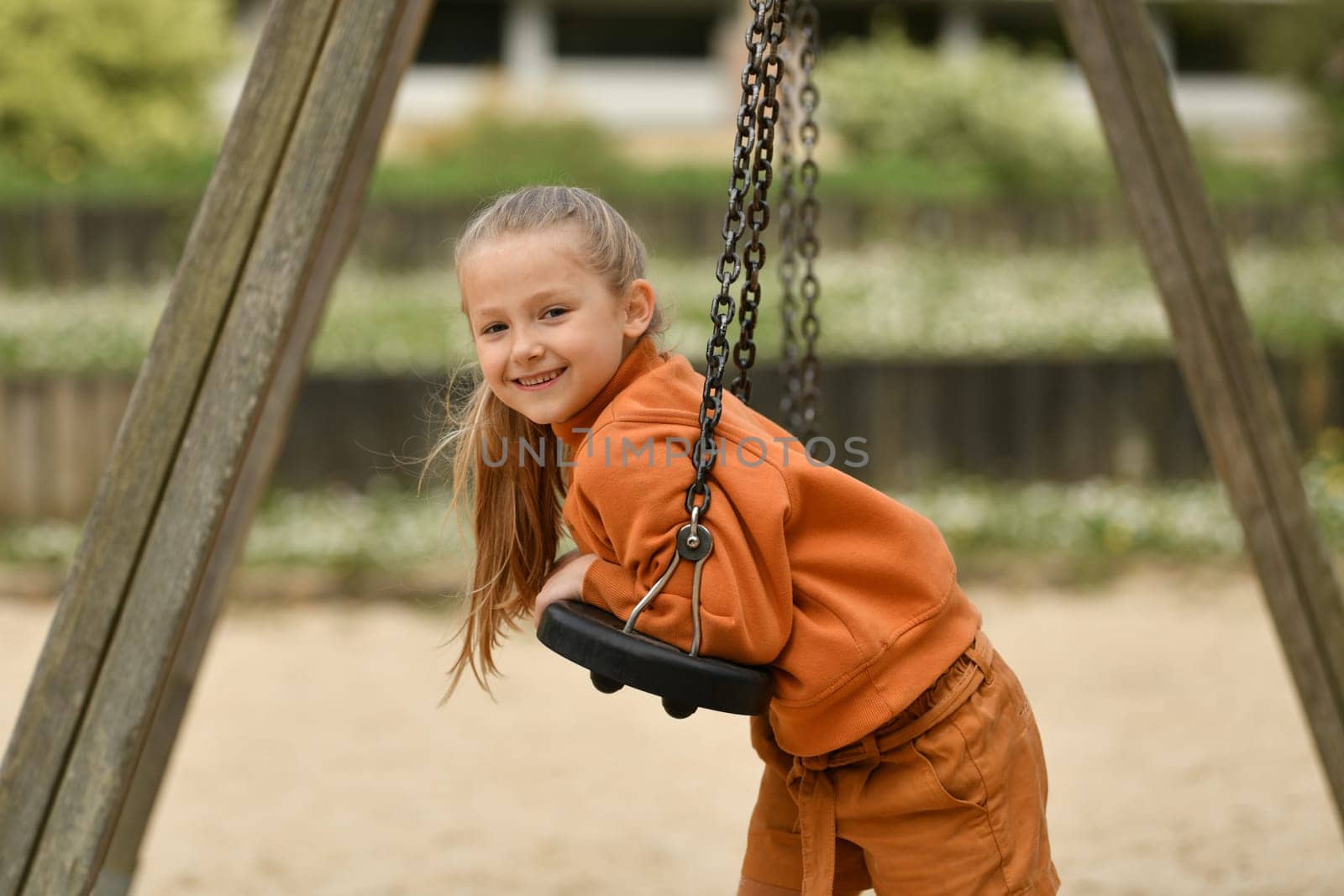 A girl riding on a swing in a park