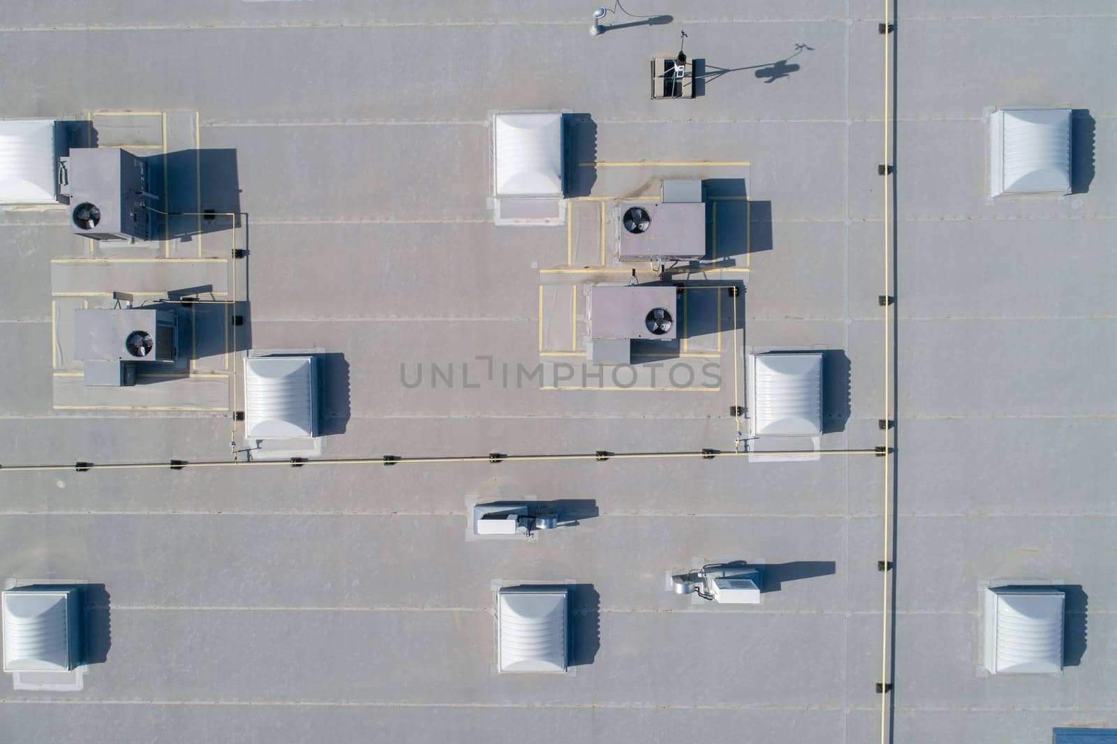 A roof with many vents and awnings. The roof is white and the vents are grey