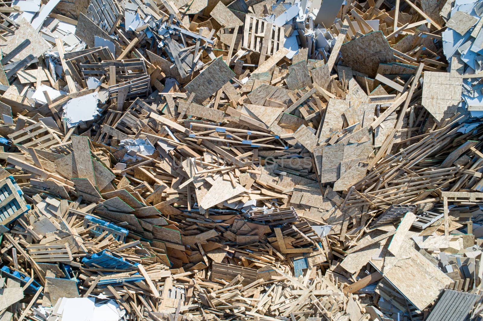 A pile of wood and debris with a lot of boards scattered around. Scene is chaotic and disorganized