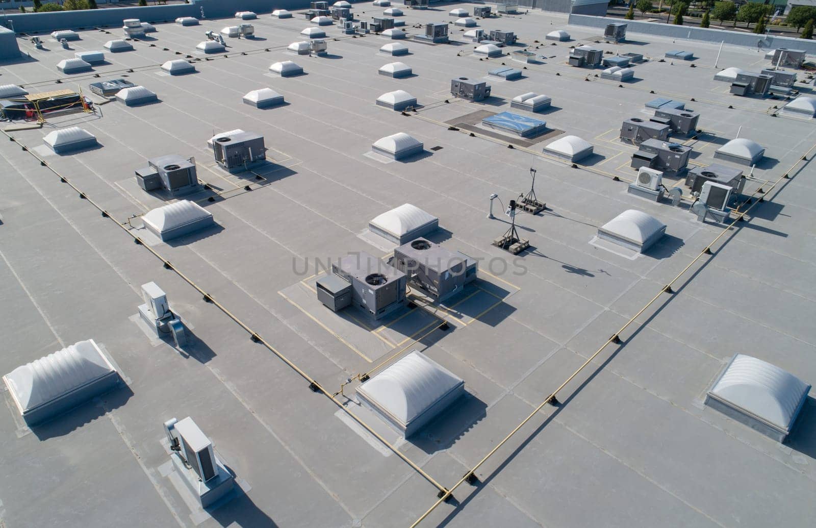 A large building with many vents and a roof. The roof is white and the vents are black