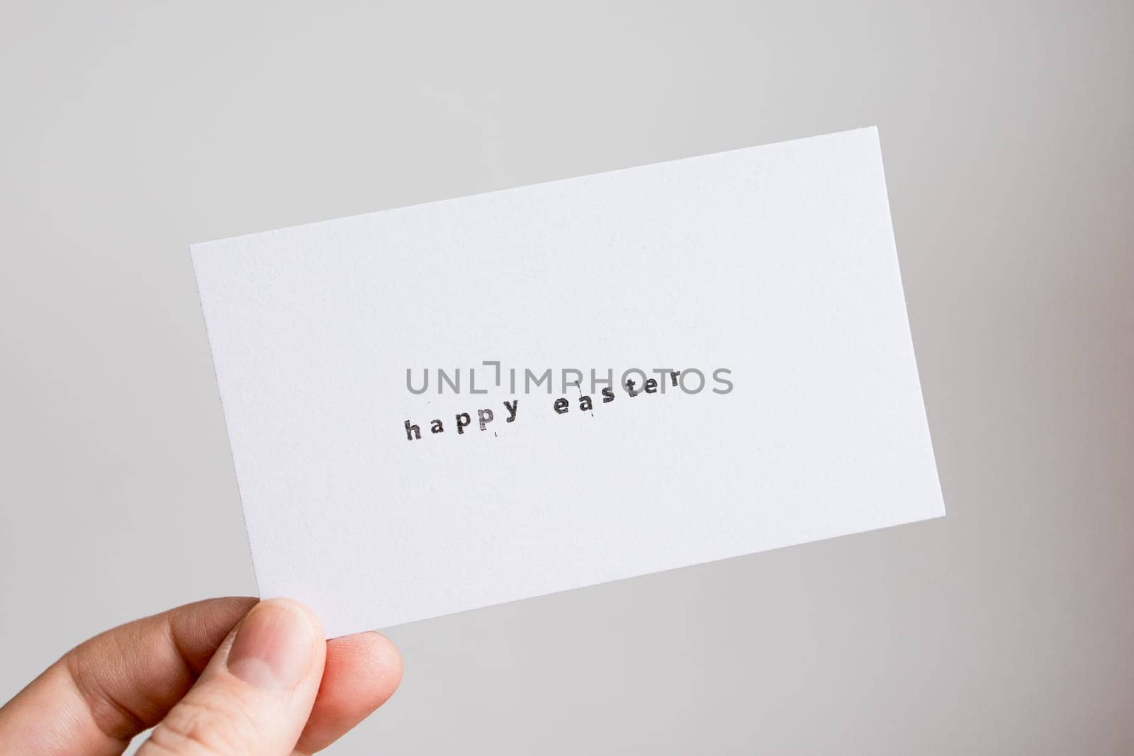 Minimalist Happy Easter card with hand-holding caucasian adult.