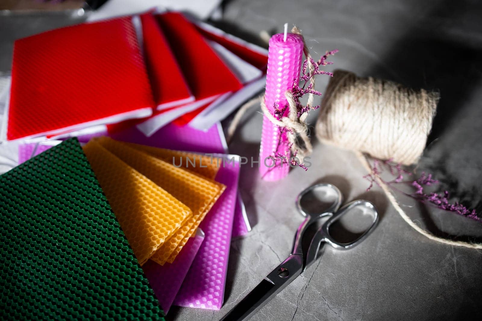 Colorful wax sheets, twine, and scissors for creative crafting projects.