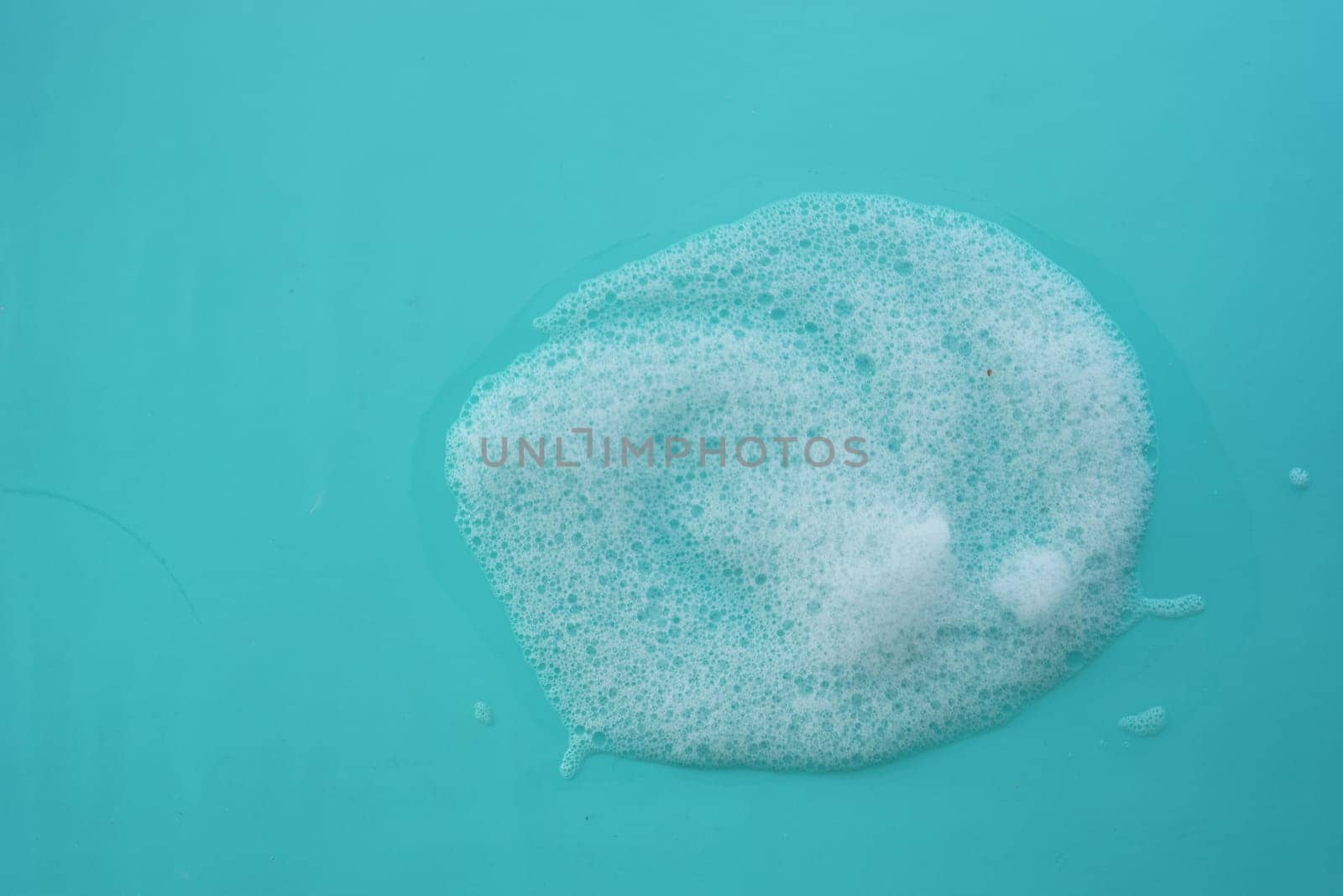 Bubbles gather on a turquoise surface, showcasing a fresh, clean atmosphere.