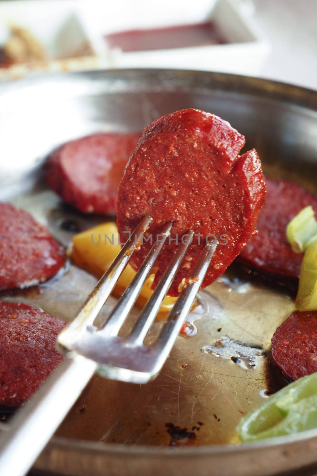 Delicious slices of sausage are cooked and ready to be enjoyed with veggies.