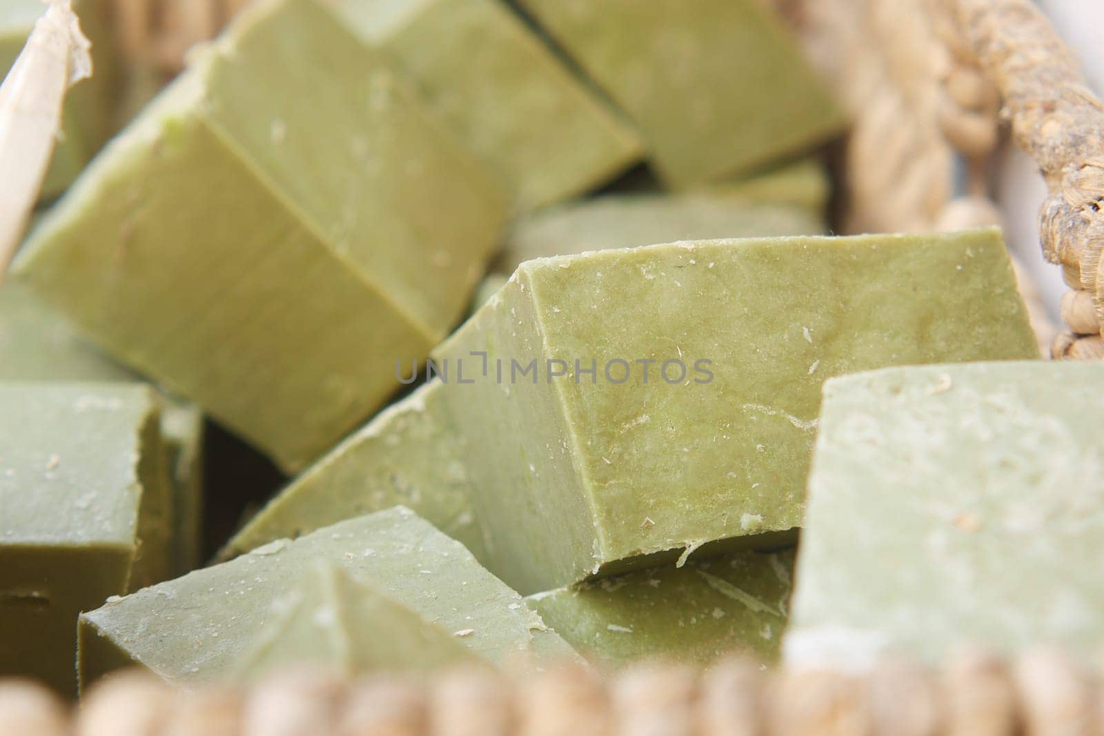 Natural green soap bars arranged neatly in a woven basket.