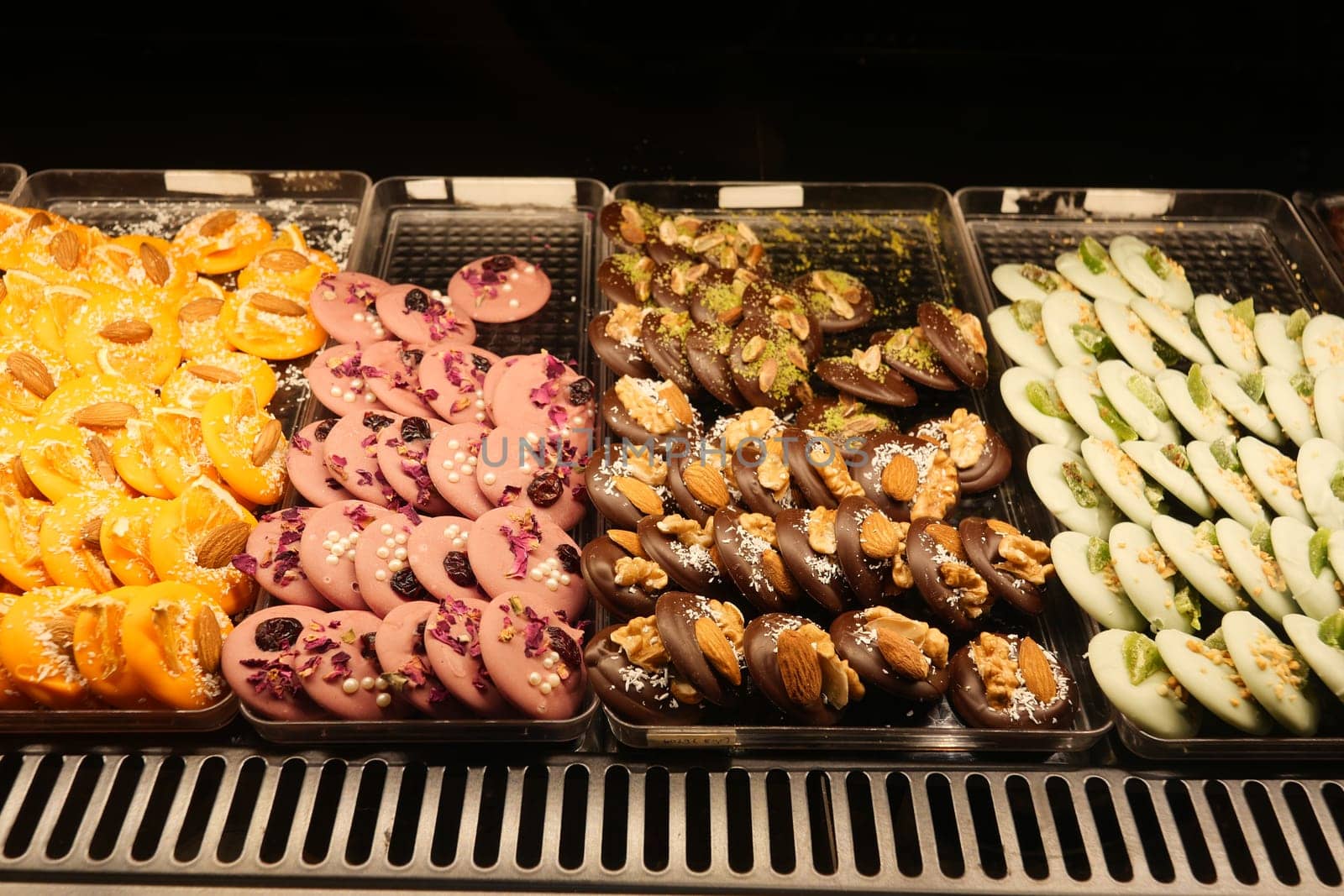 Various traditional sweets arranged in neat sections at a market stall.