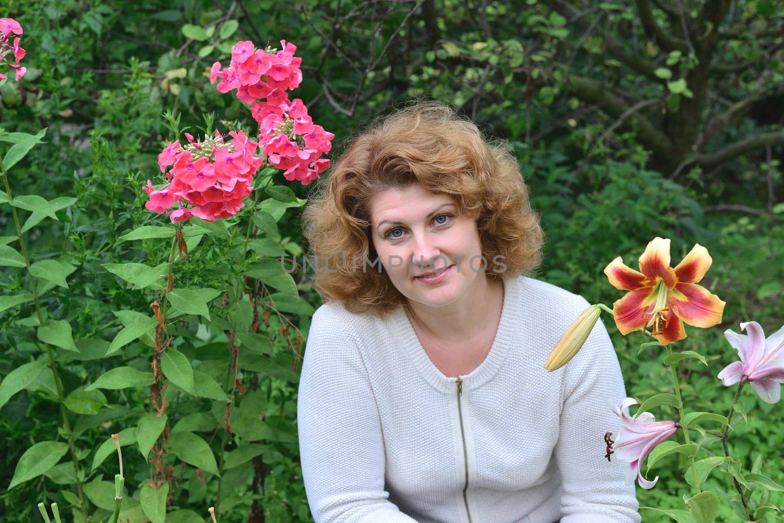 Woman in garden surrounded by a flowers