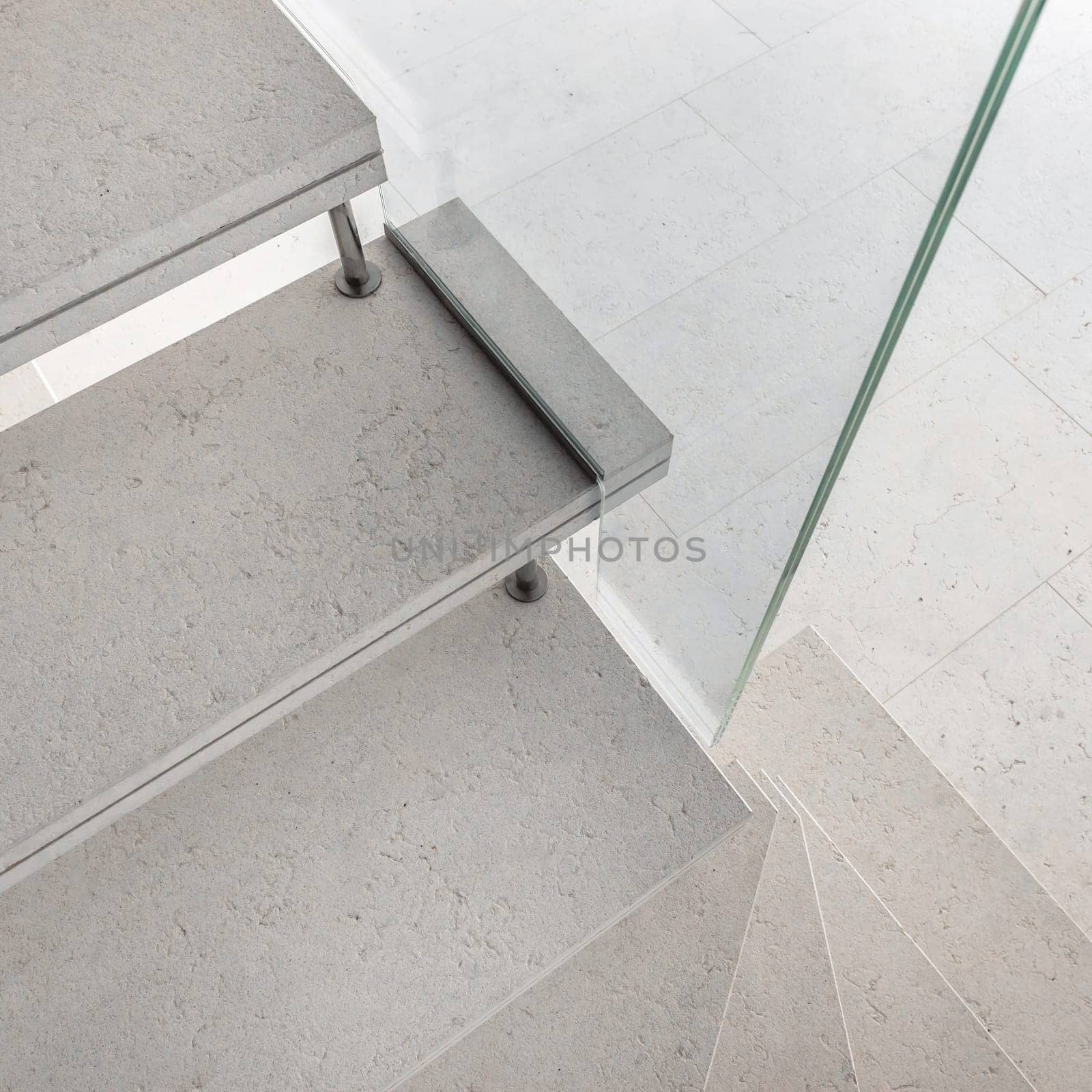 Microcement stairs with glass handrail. Stairs viewed from above. Modern design and innovative material. Glass railing.