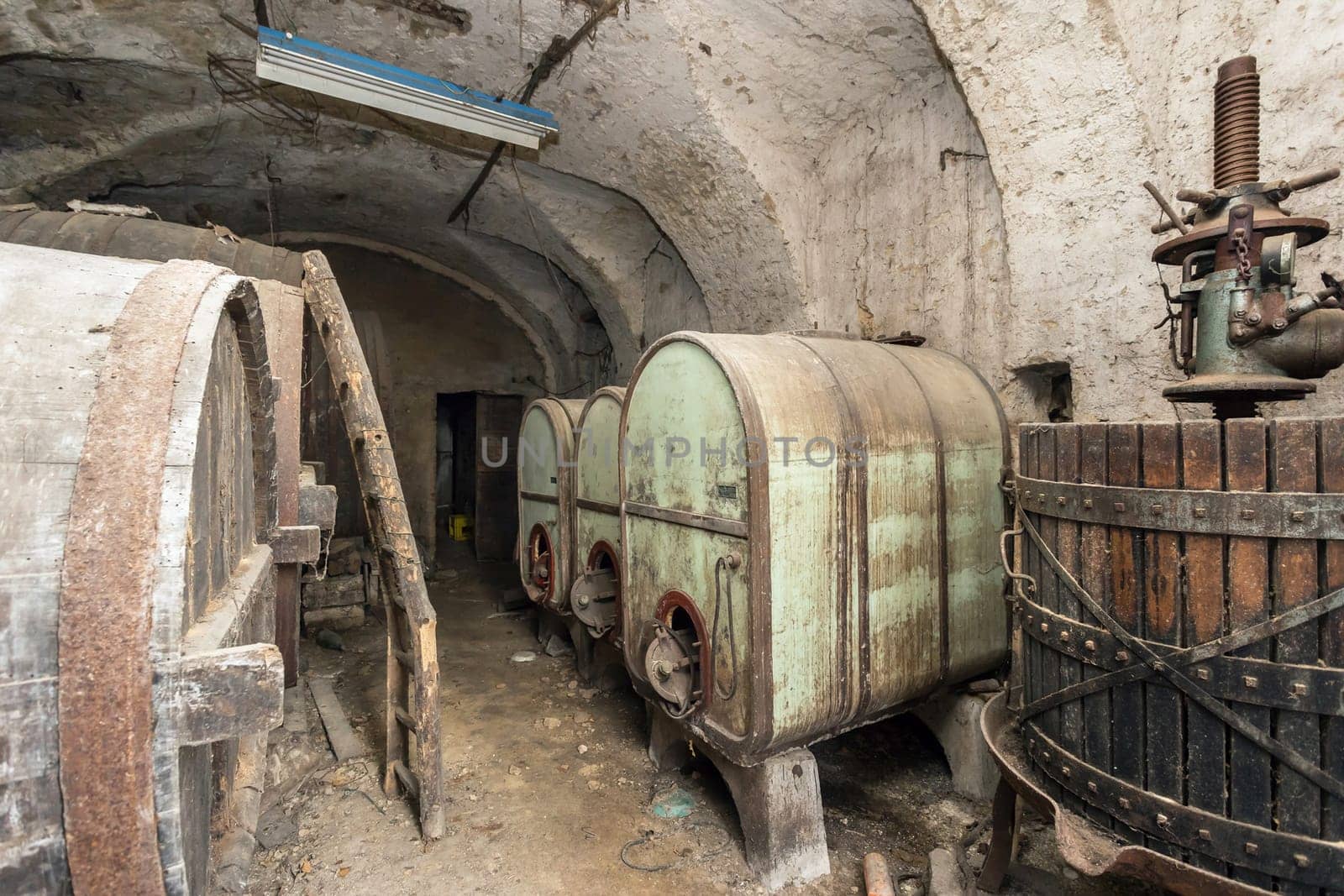 Vintage cellar winery with dusty bottles and wine barrels