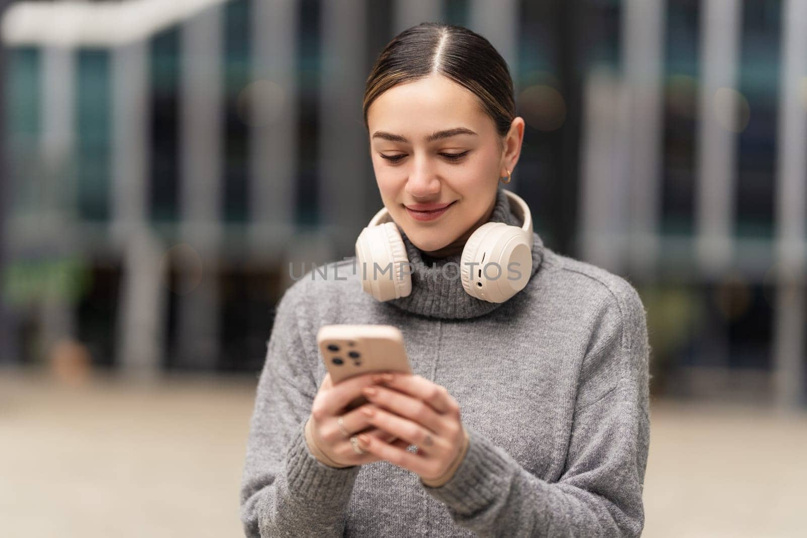 Work from anywhere, thrive everywhere. A remote freelancer in casual wear uses headphones and a phone to manage projects on the go, embracing the freedom of digital nomadism.