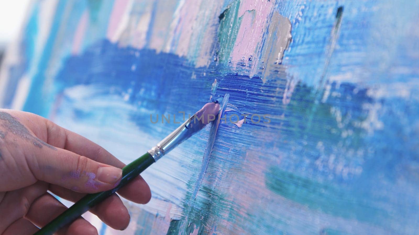 Drawing an abstract painting with a brush and oil paints. Mid shot