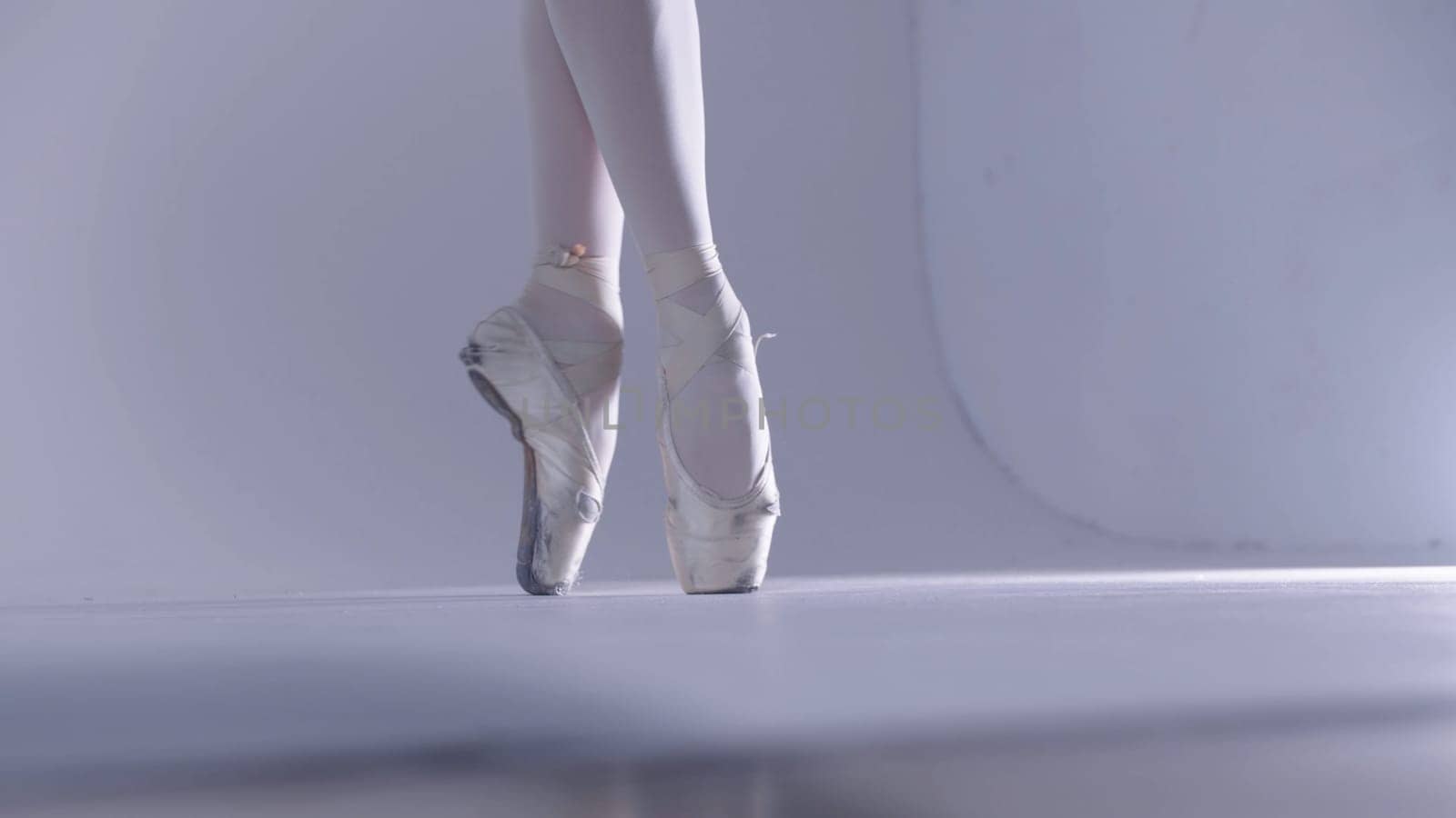 Young woman ballerina walking on pointe shoes. Mid shot