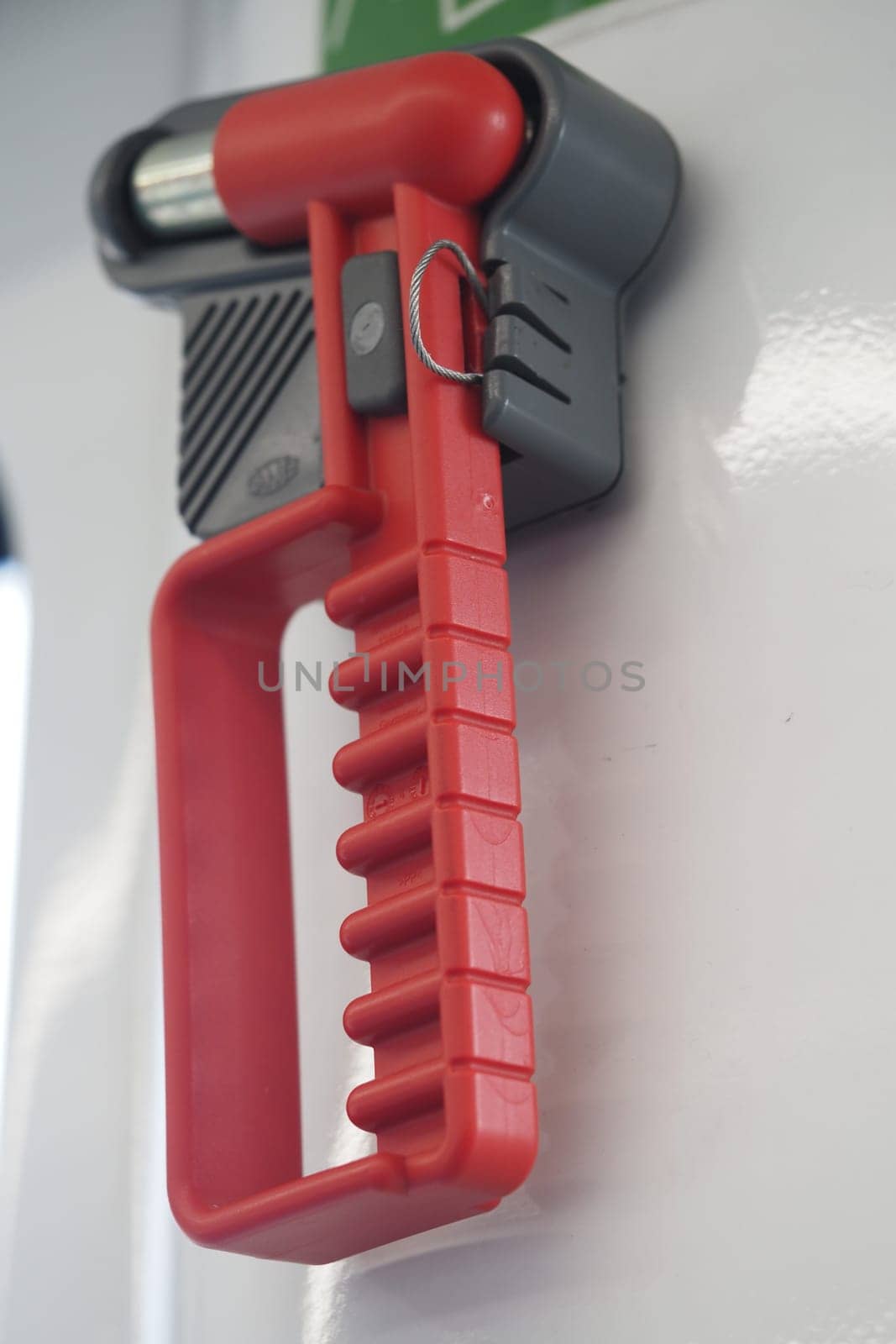 A red utility handle provides stability for passengers on a train.