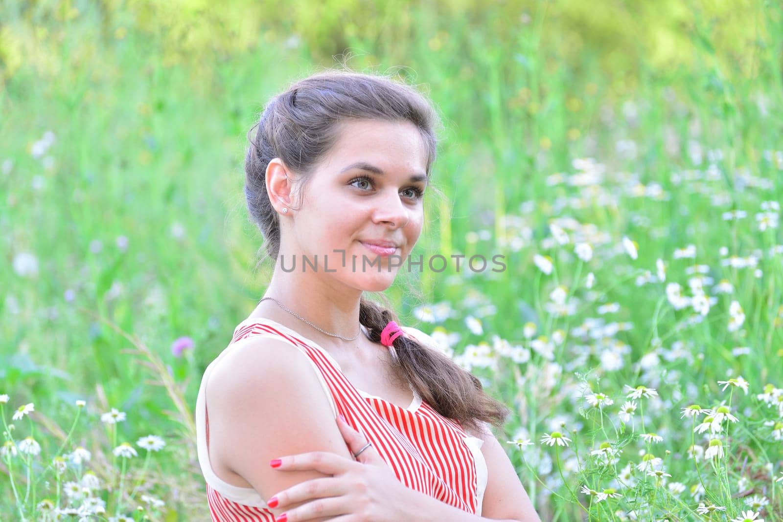 Happy 16 year old girl surrounded by a blooming field