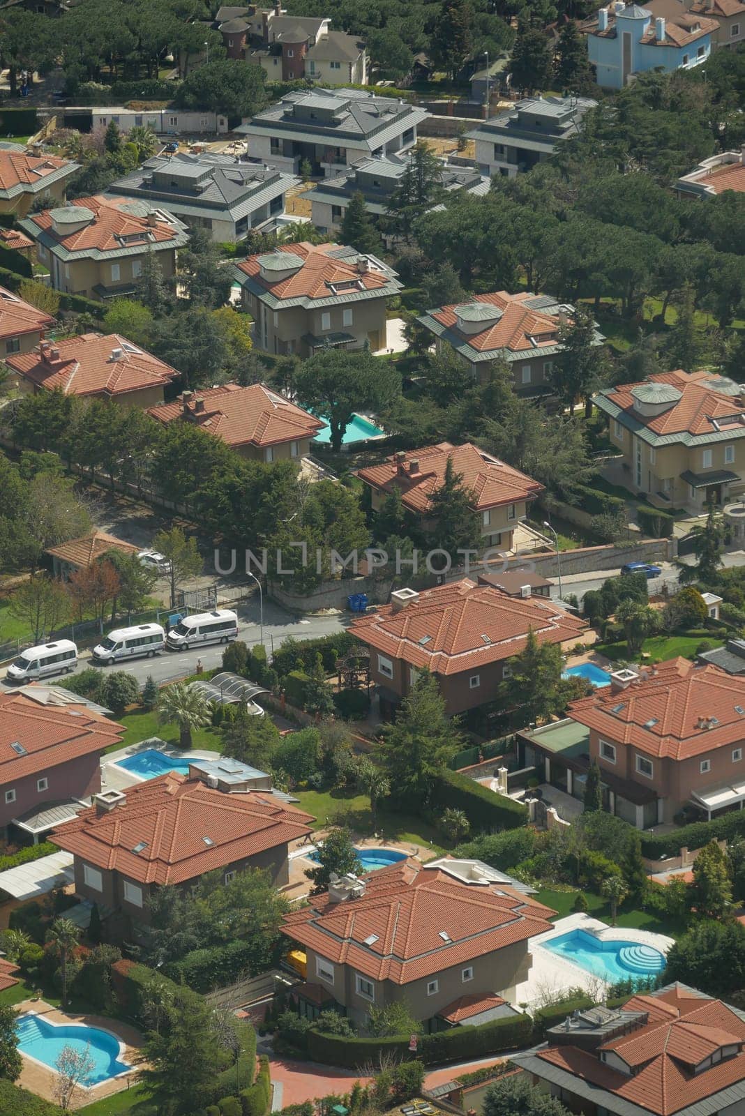 Aerial view of lovely homes with pools in a green neighborhood.