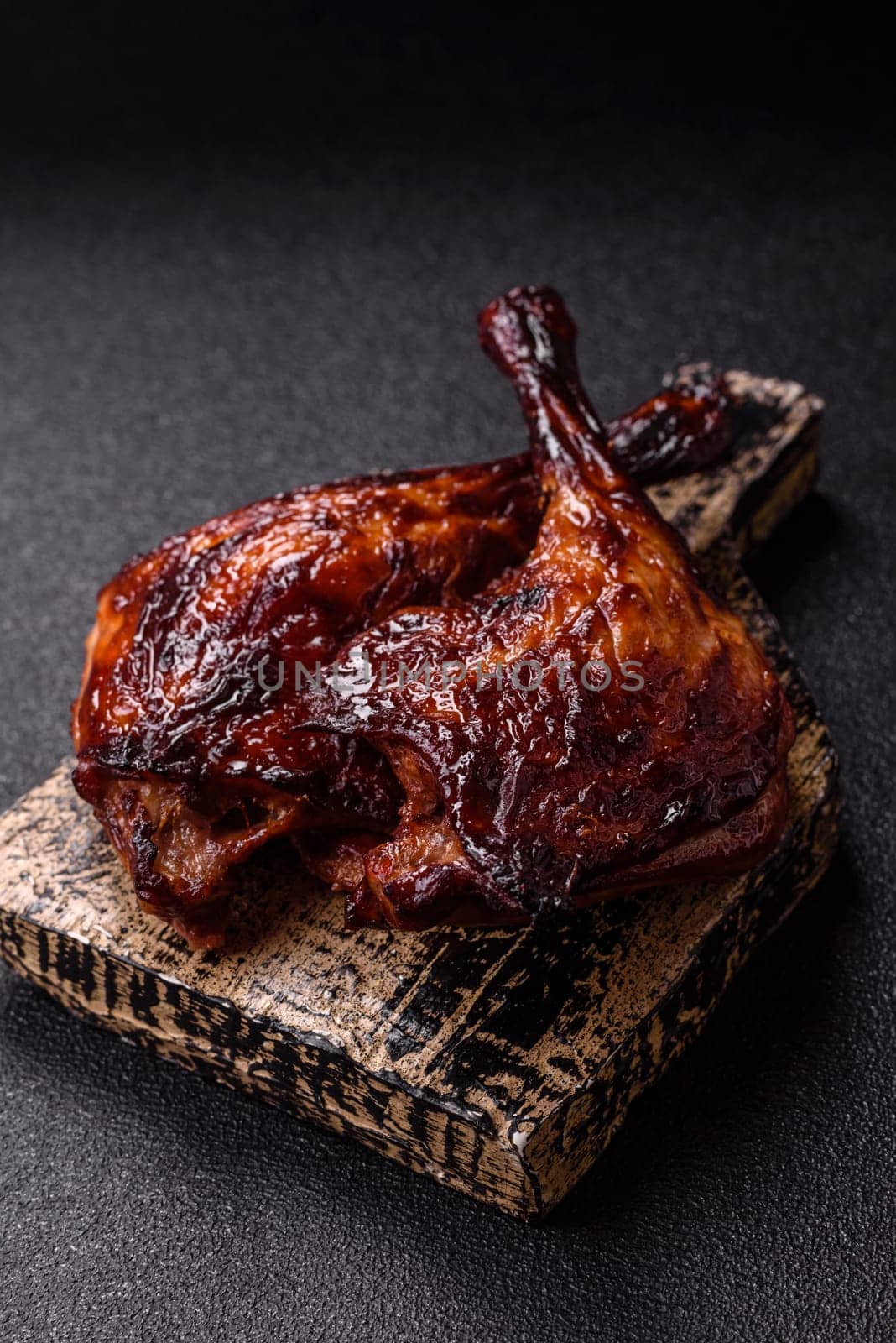 Duck, chicken leg or thigh grilled on a dark concrete background. Duck confit, Asian food with salt and spices