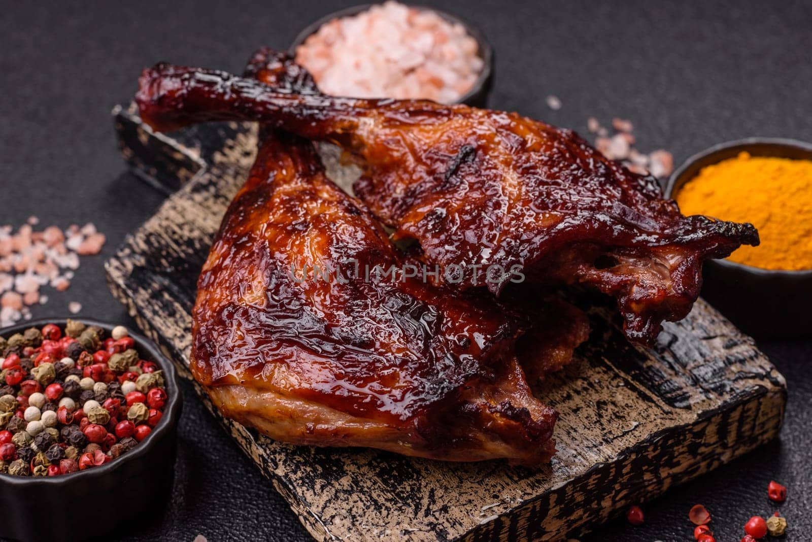 Duck, chicken leg or thigh grilled on a dark concrete background. Duck confit, Asian food with salt and spices