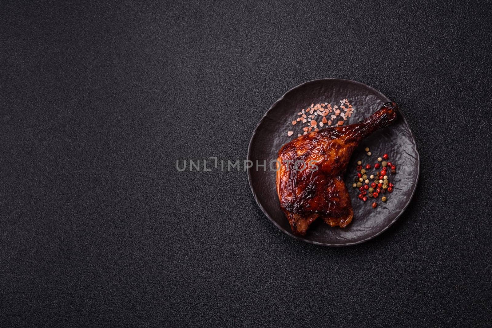 Duck, chicken leg or thigh grilled on a dark concrete background. Duck confit, Asian food with salt and spices