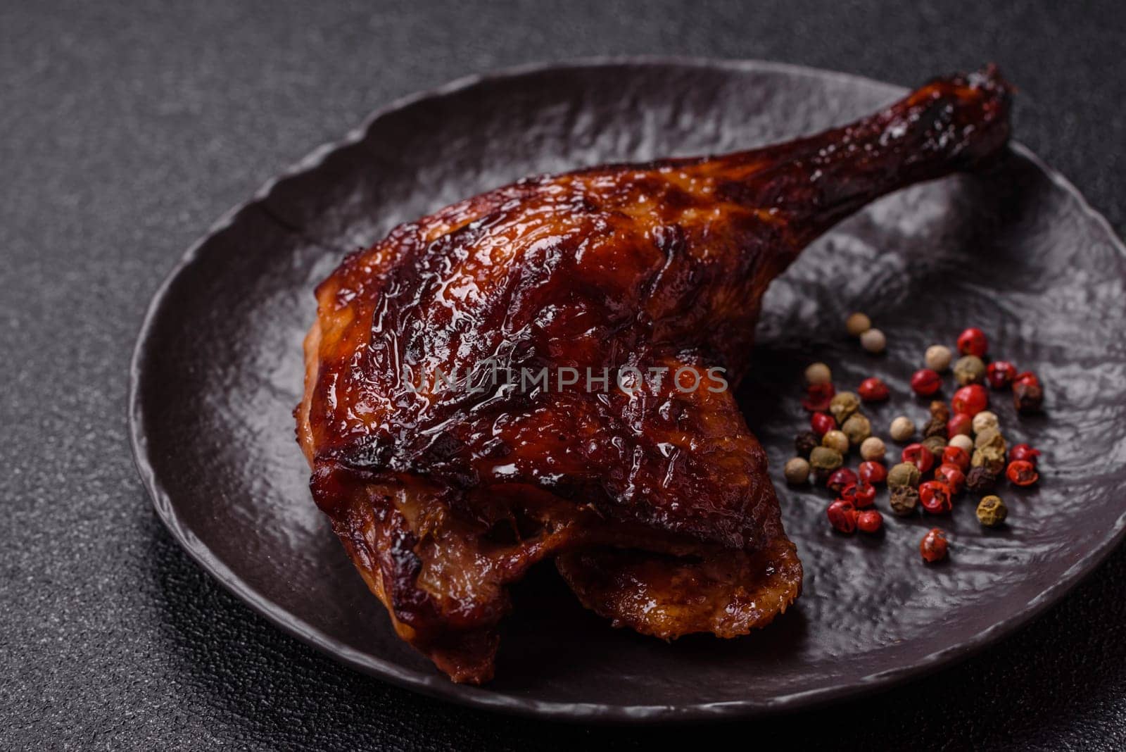 Duck, chicken leg or thigh grilled on a dark concrete background. Duck confit, Asian food with salt and spices
