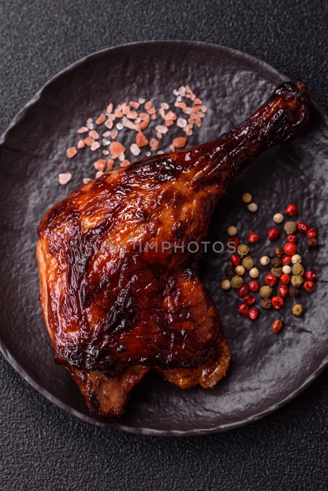 Duck, chicken leg or thigh grilled on a dark concrete background. Duck confit, Asian food with salt and spices