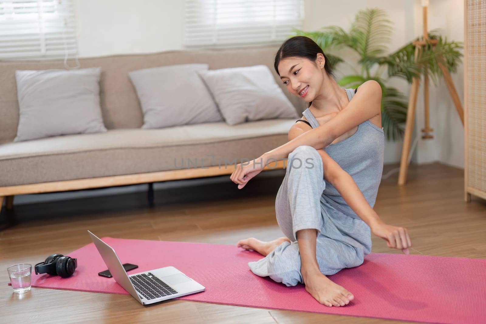 Enjoying a calming routine, a woman incorporates various yoga stretches, enhancing her mobility and mental clarity in a cozy setting.
