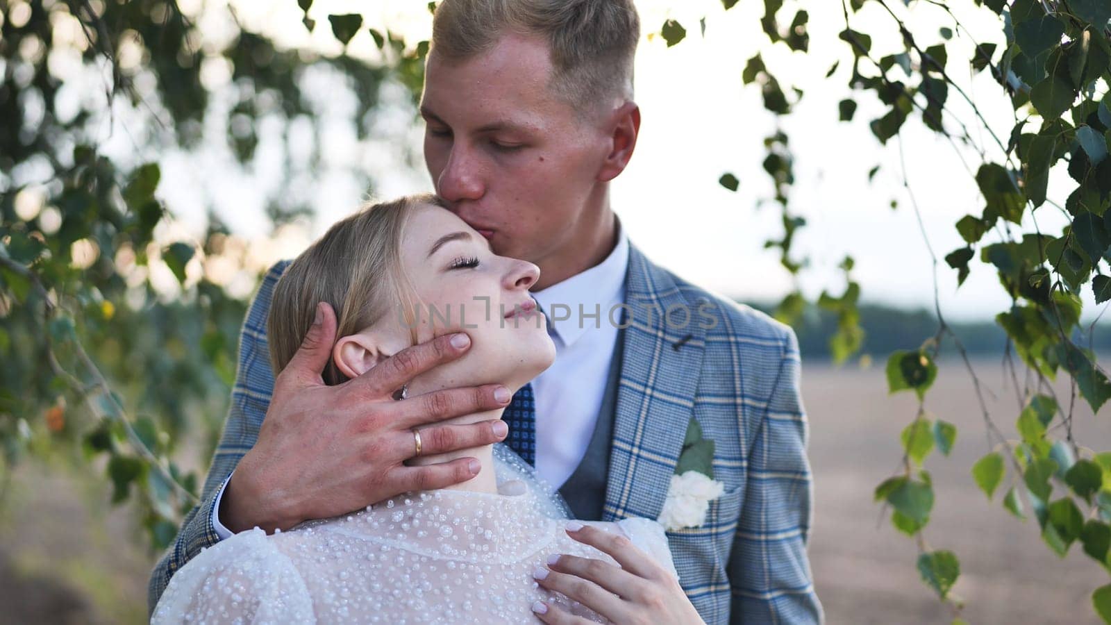 Loving newlyweds embracing near birch tree, capturing intimate wedding moment with gentle togetherness and heartfelt connection