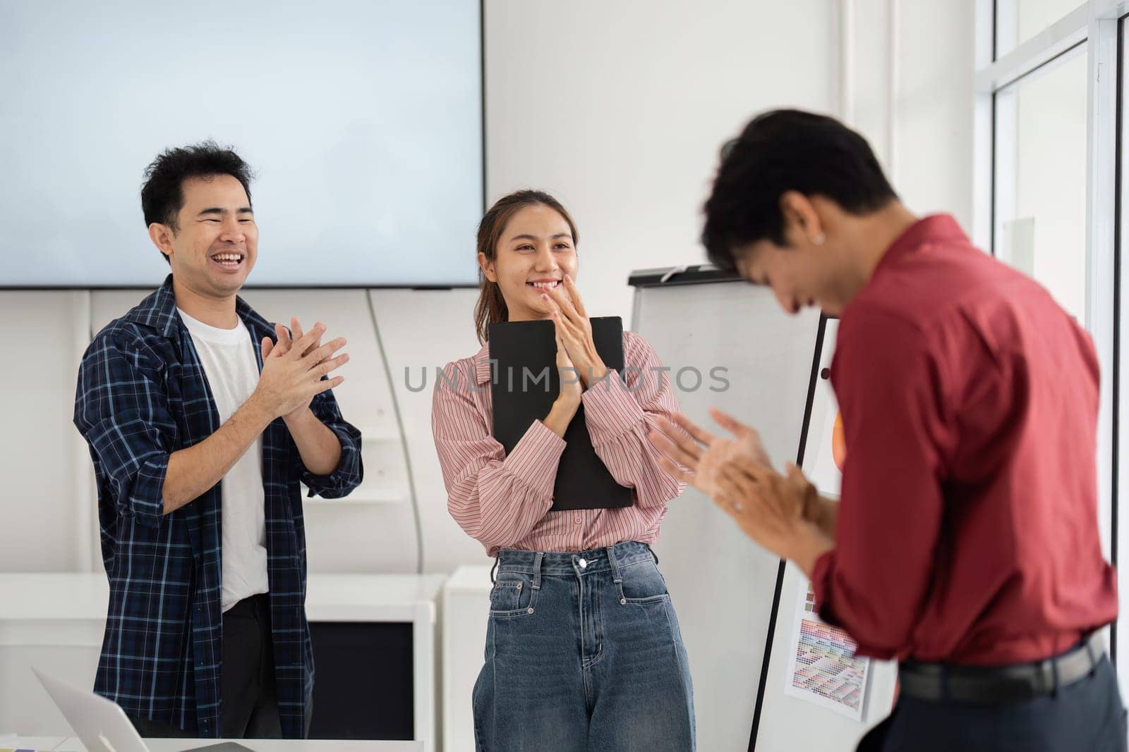 In an inspiring environment, team members applaud their colleague's ideas, highlighting an atmosphere of appreciation and collaborative spirit in the workplace.