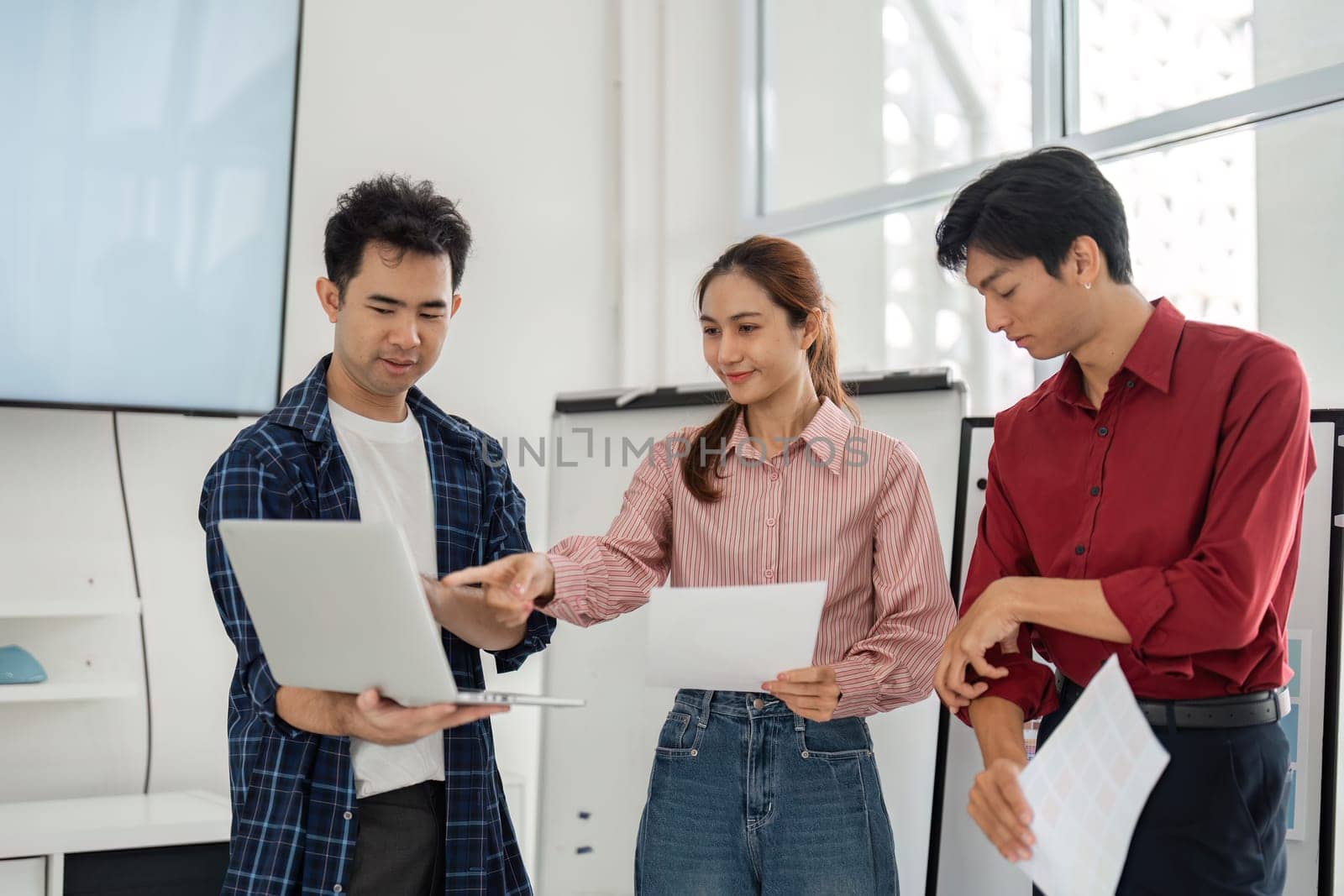 In a vibrant office setting, team members focus on new design trends as they analyze reports and visuals, demonstrating teamwork and a shared commitment to innovative solutions.