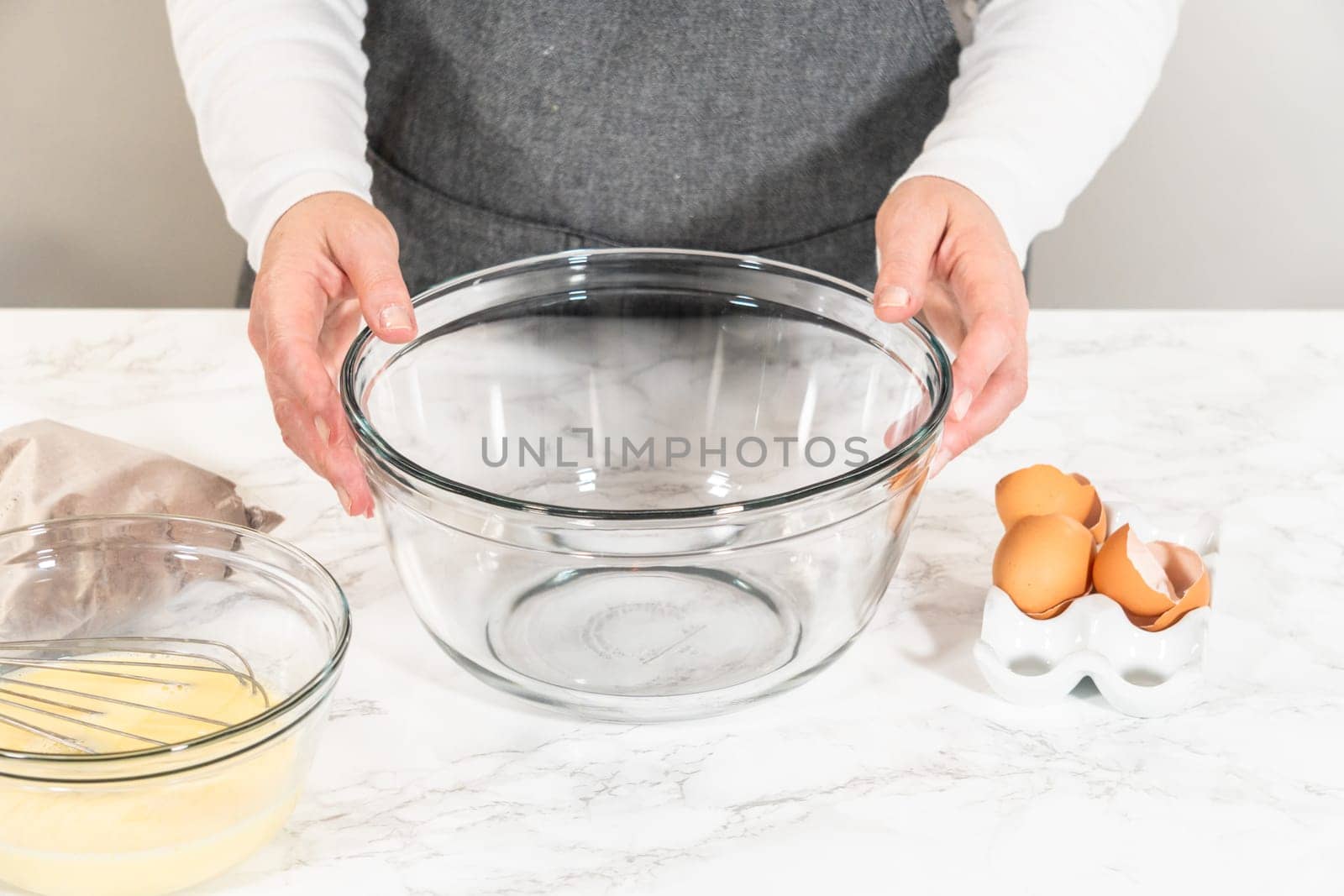 In the process of creating mouthwatering chocolate cupcakes, the first step involves meticulously mixing the ingredients in a glass mixing bowl to make the perfect batter.