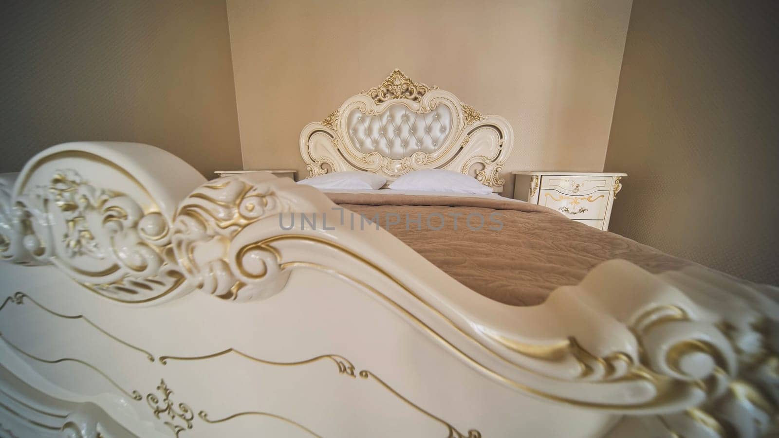 Luxurious bed featuring white and gold ornate carvings, creating an elegant and romantic atmosphere in a bedroom, ideal for a wedding day celebration
