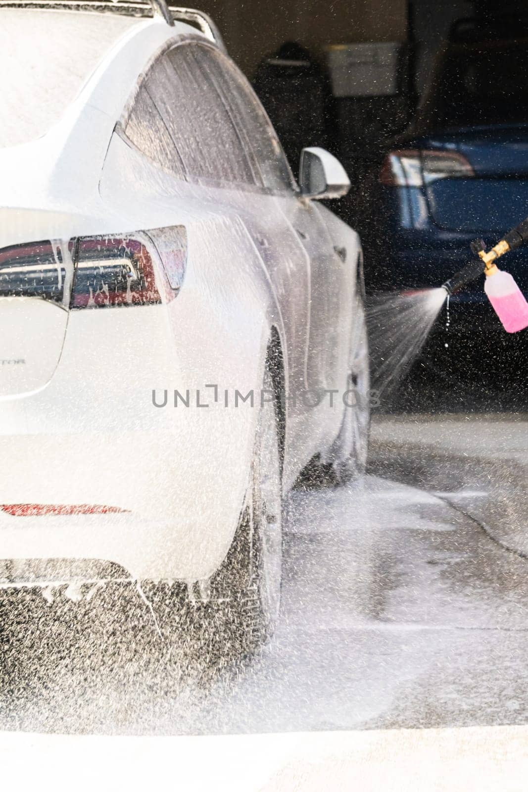 Efficiently cleaning an electric car in the comfort of a suburban driveway, combining eco-consciousness with practicality.