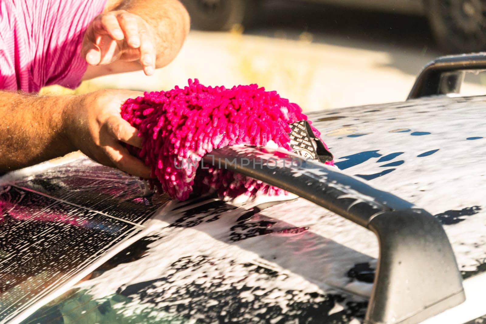 Efficiently cleaning an electric car in the comfort of a suburban driveway, combining eco-consciousness with practicality.