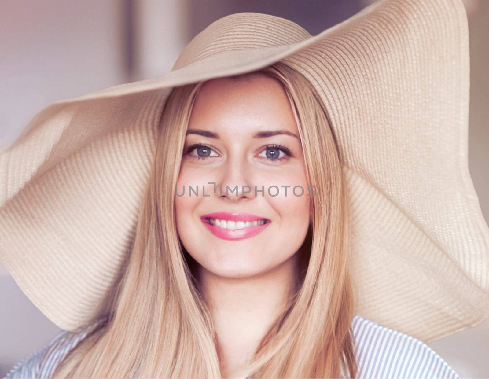 Woman, fashion and summer country charm, blonde beauty and elegance in wide brimmed beach hat. Feminine allure, timeless style and graceful glow. Smile, straw hat and blue striped blouse, natural lighting and effortless charm, fashion look idea