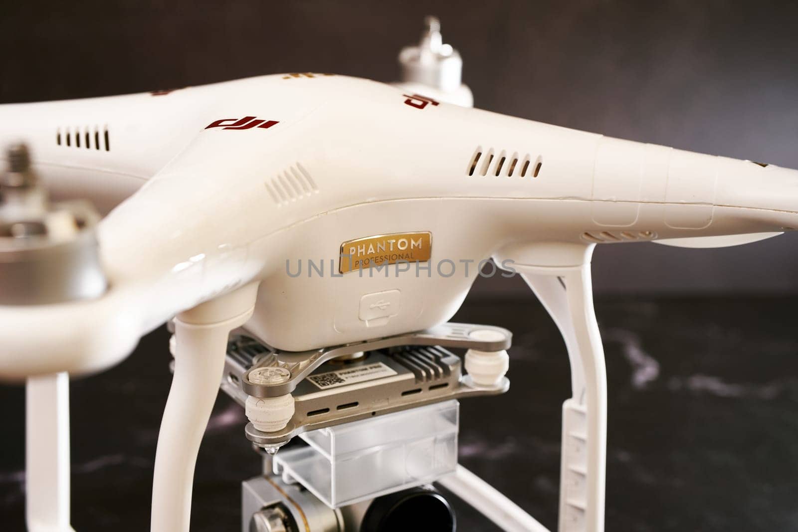 White DJI drone stands on a black table. Caption: Phantom Professional. High quality photo