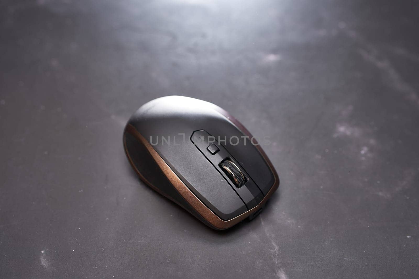 Wireless mouse lies on a black table. Top view. High quality photo
