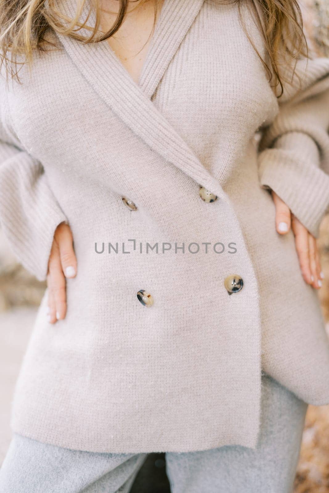 Young woman rests her hands on her hips. Cropped. Faceless. High quality photo