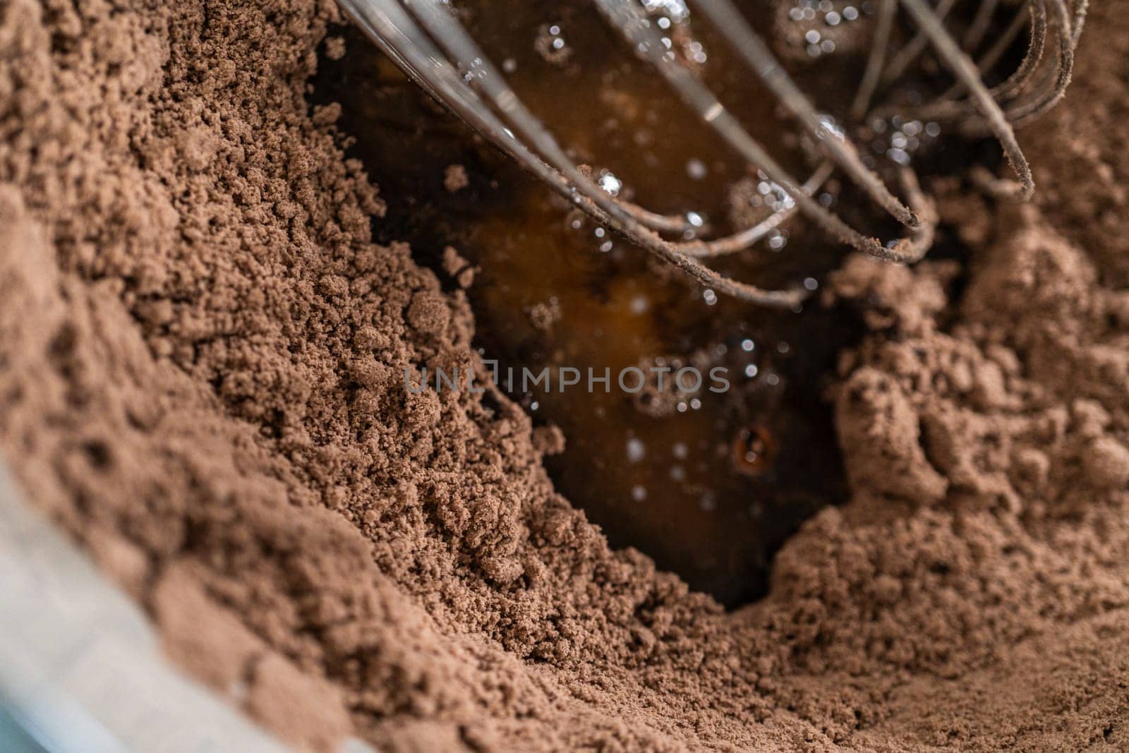 In the process of creating mouthwatering chocolate cupcakes, the first step involves meticulously mixing the ingredients in a glass mixing bowl to make the perfect batter.