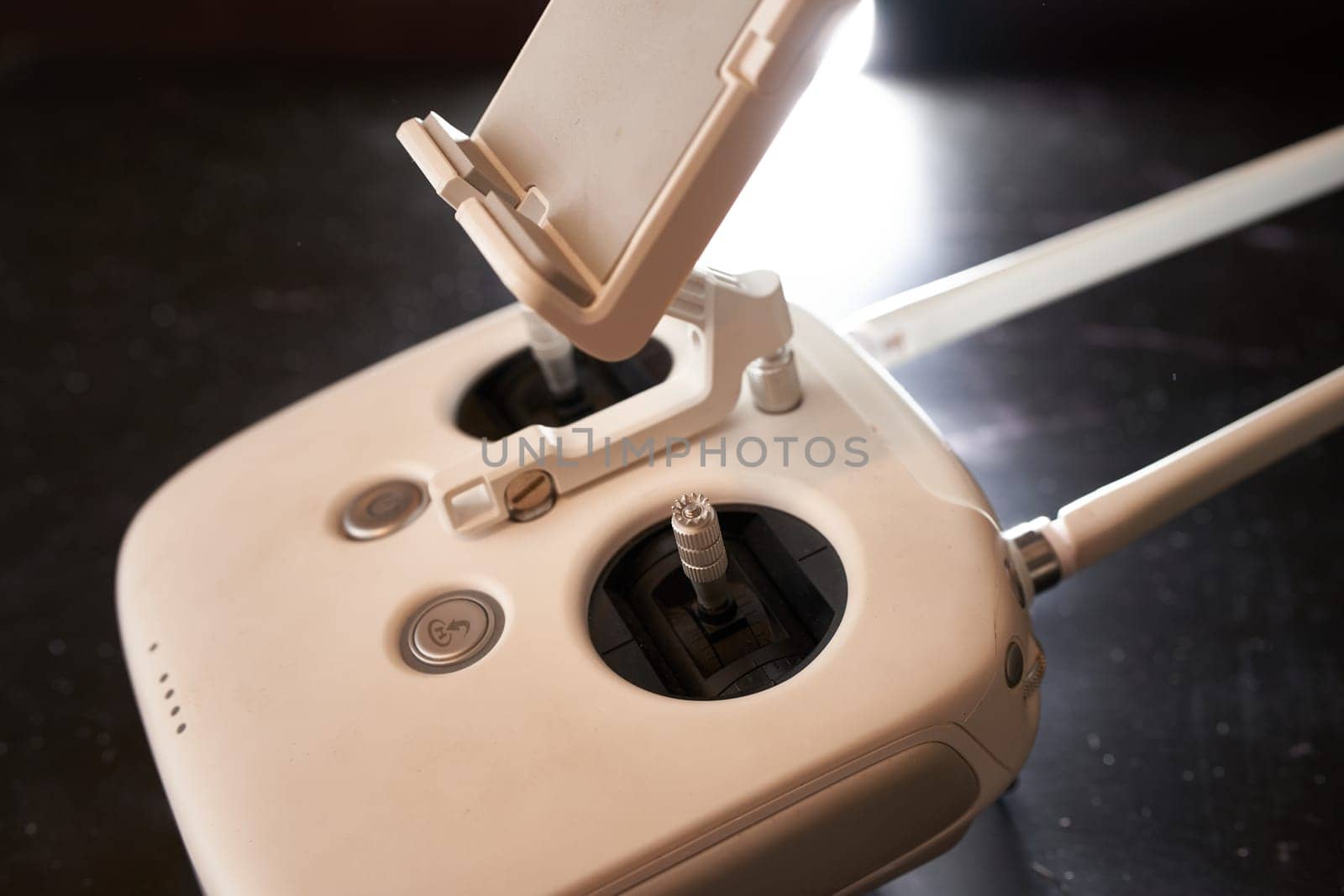 DJI Phantom 3 drone remote control stands on a black table. Side view. High quality photo