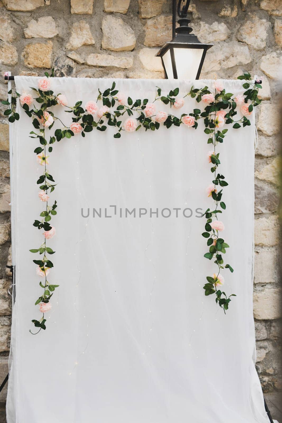 Arch decoration of flowers on white fabric background for photographing newlyweds and guests