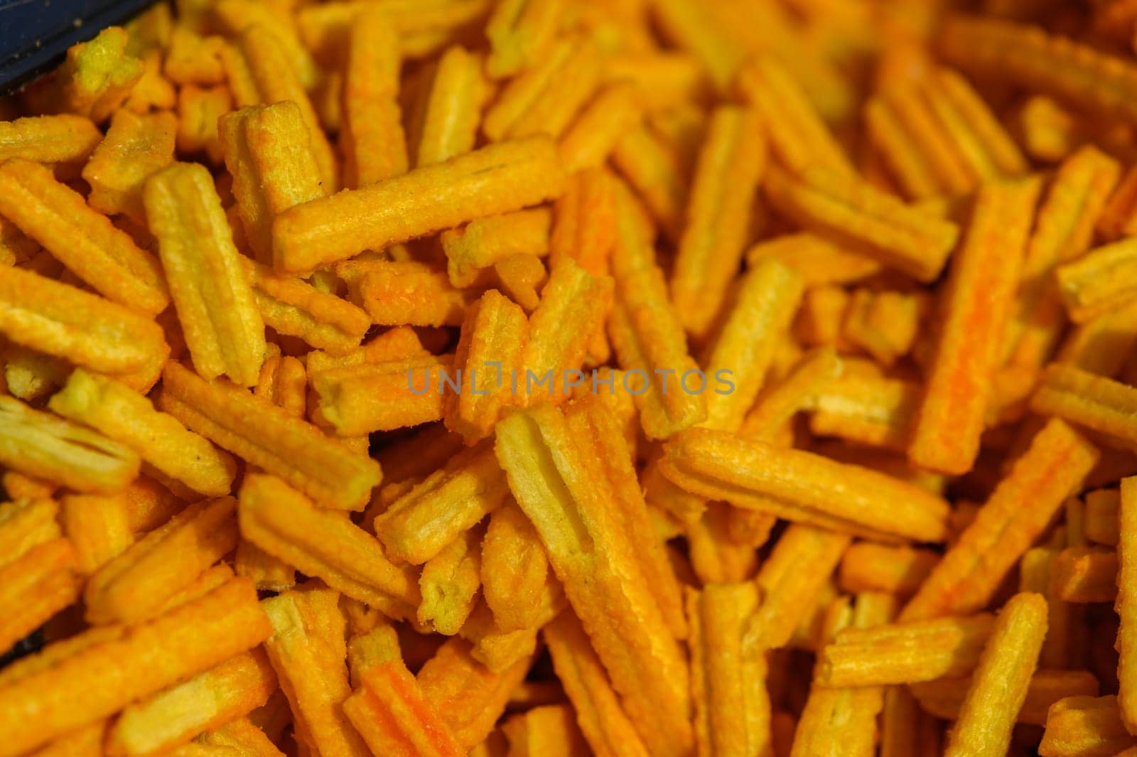 A colorful assortment of crunchy yellow snacks fills the display, tempting visitors with their irresistible texture and inviting colors. Perfect for sharing at gatherings.