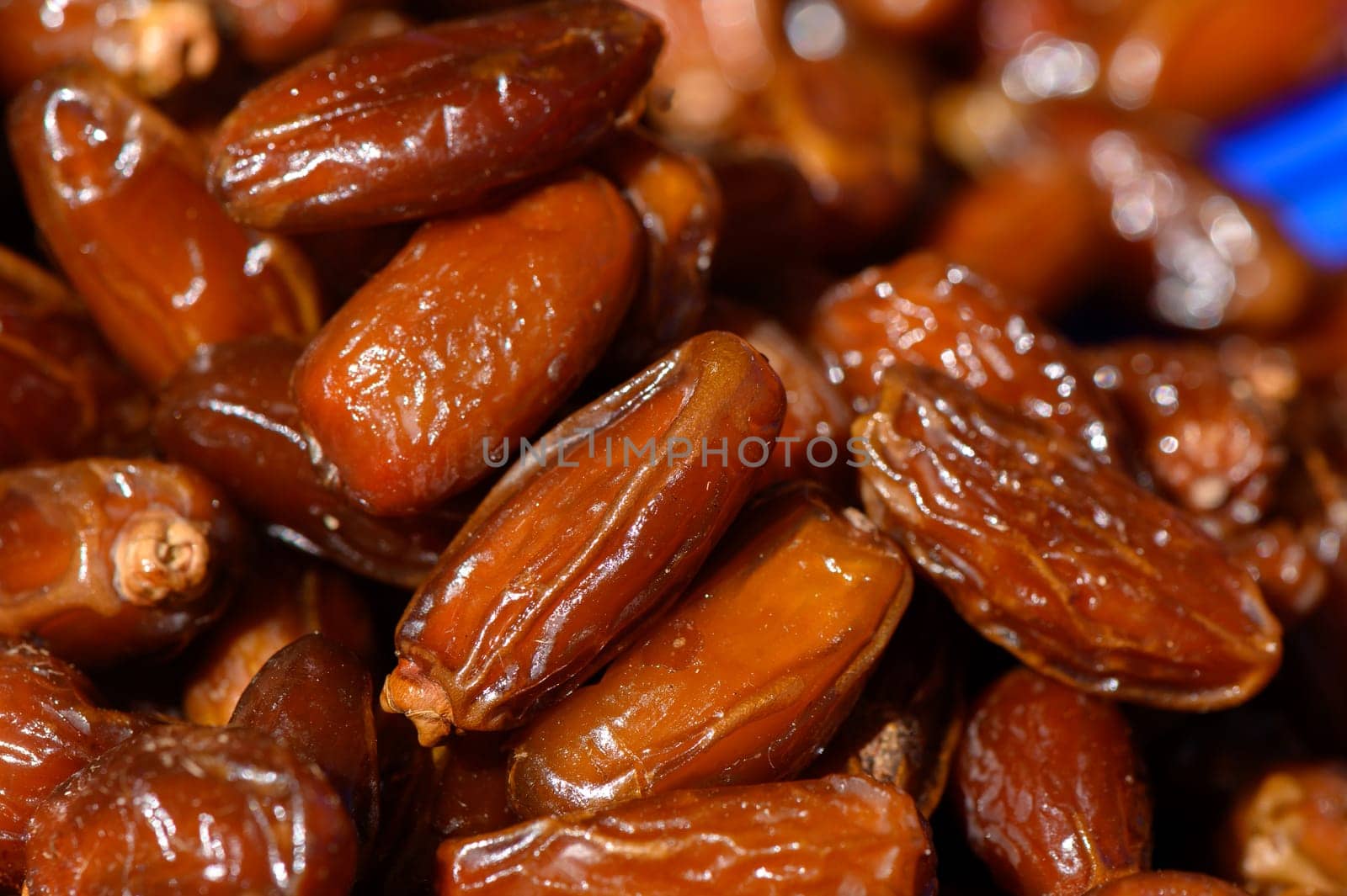 A close-up view reveals clusters of shiny dried dates, their rich brown hue showcasing the natural sweetness. These delectable treats are often enjoyed in various culinary delights.