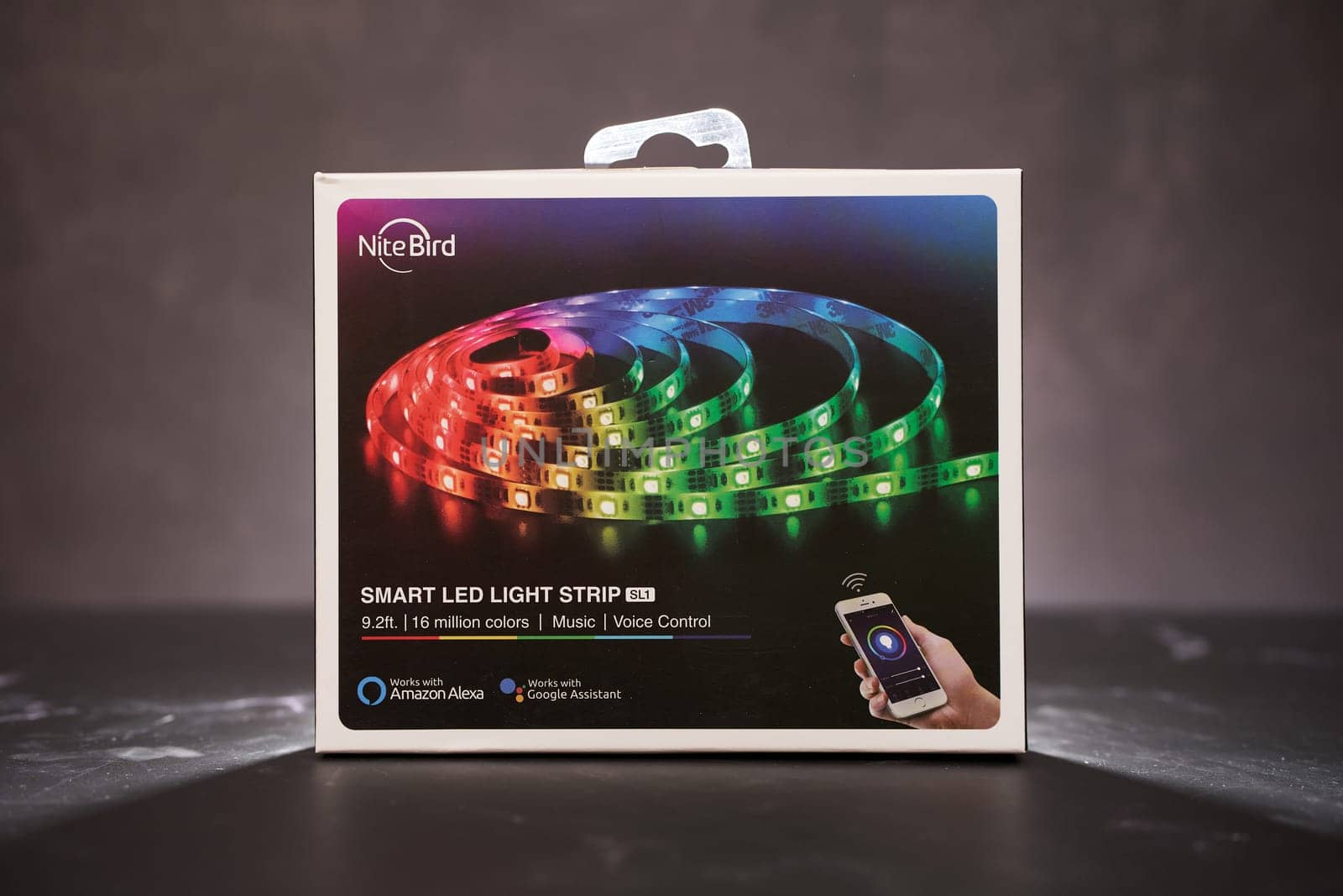 Smart LED strip NiteBird SL1 in original packaging stands on a black table. High quality photo