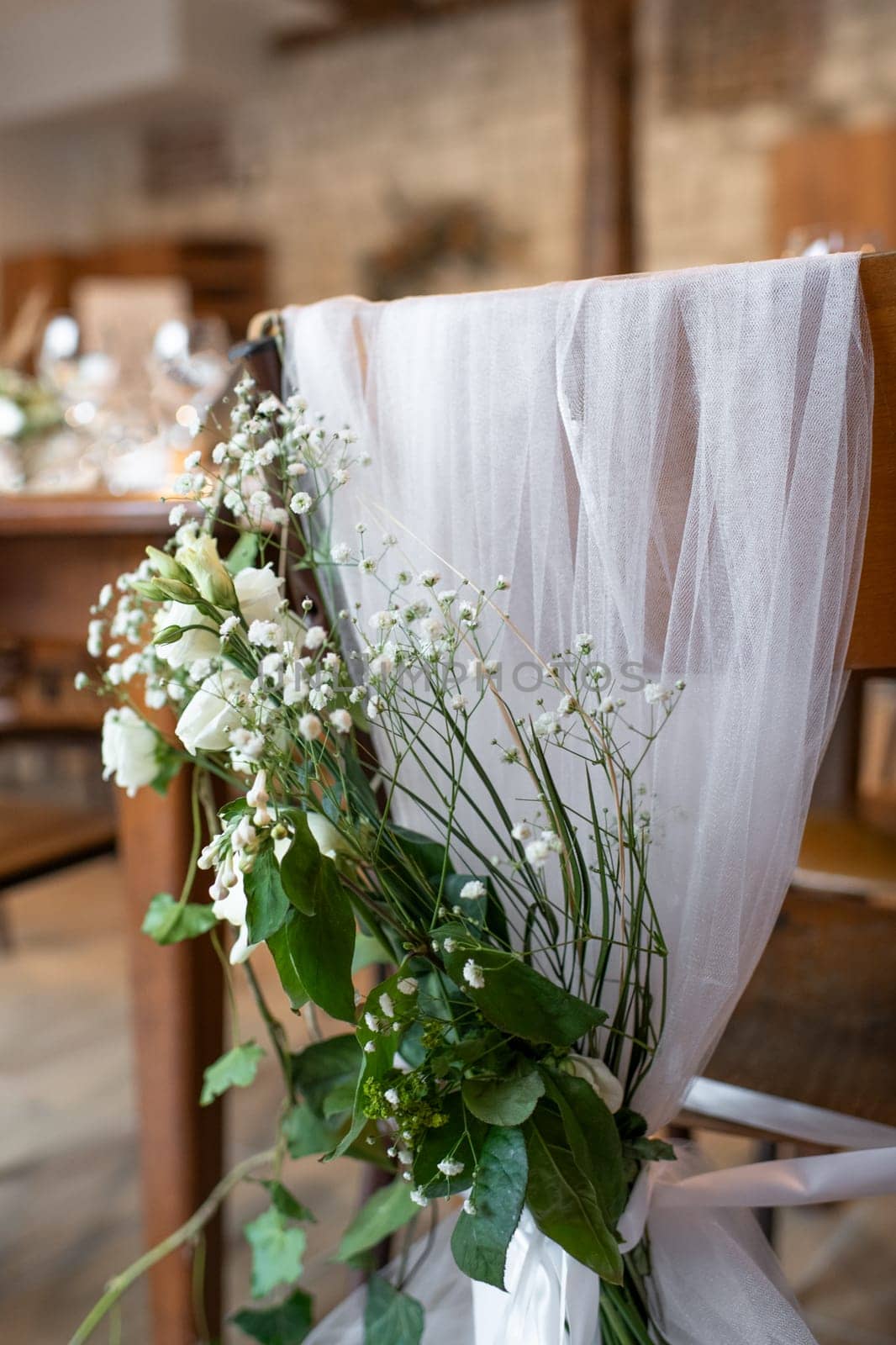 Wedding chairs decorated with white cloth and flowers
