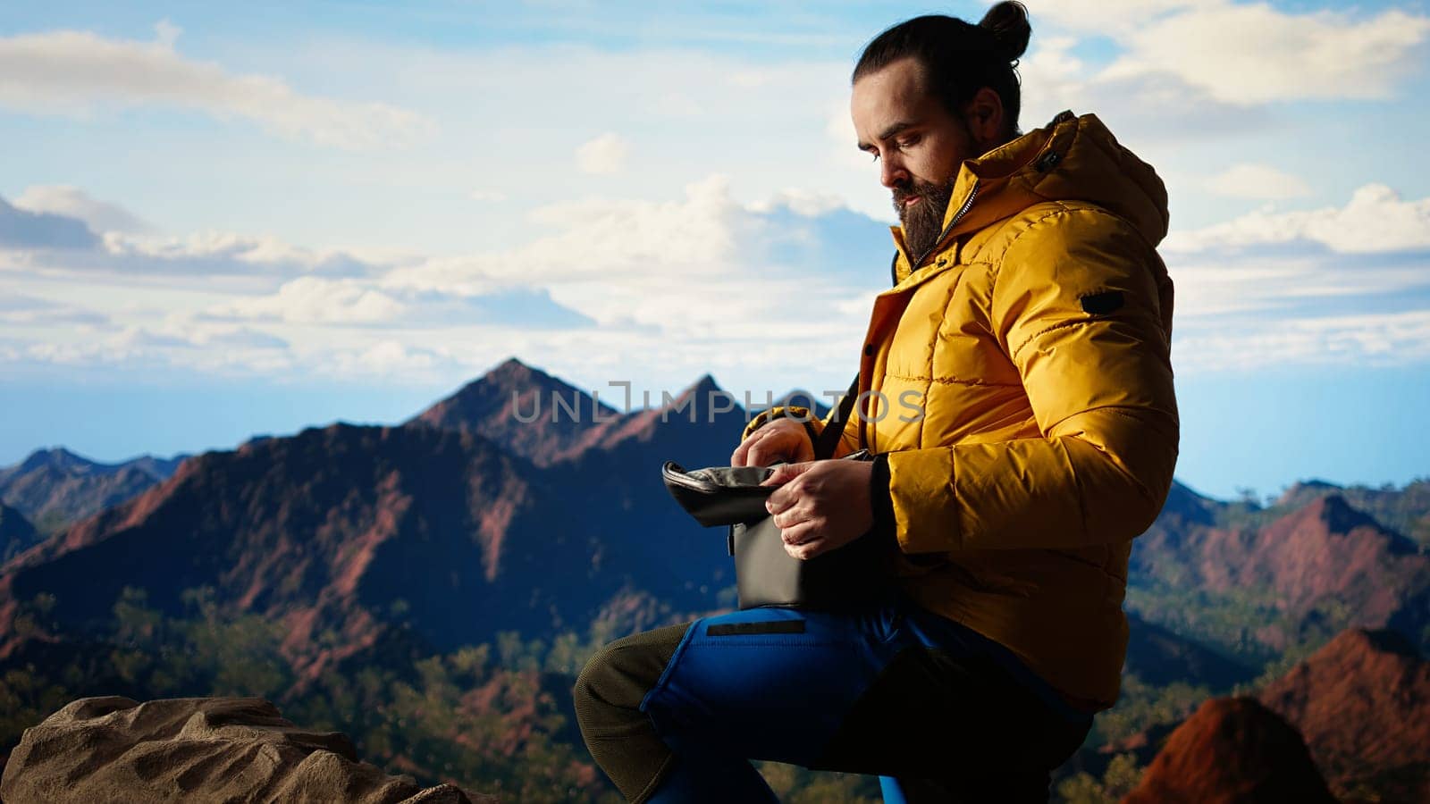 Photographer recording professional content with his drone on a mountain top, hiking in wilderness and capturing scenic landscape video. Aerial photography of wild nature. Camera A.