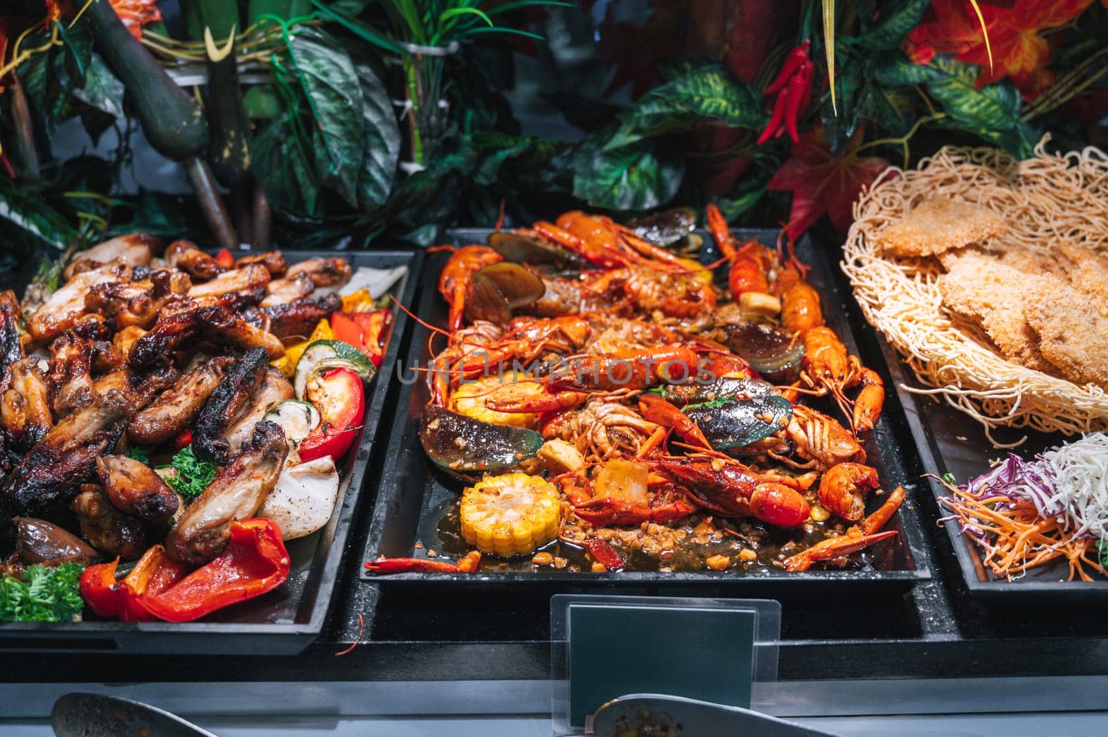 hot dishes garnish at Asian buffet in hotel in restaurant for breakfast. Fried chicken meat and crayfish at the Asian night market in Vietnam