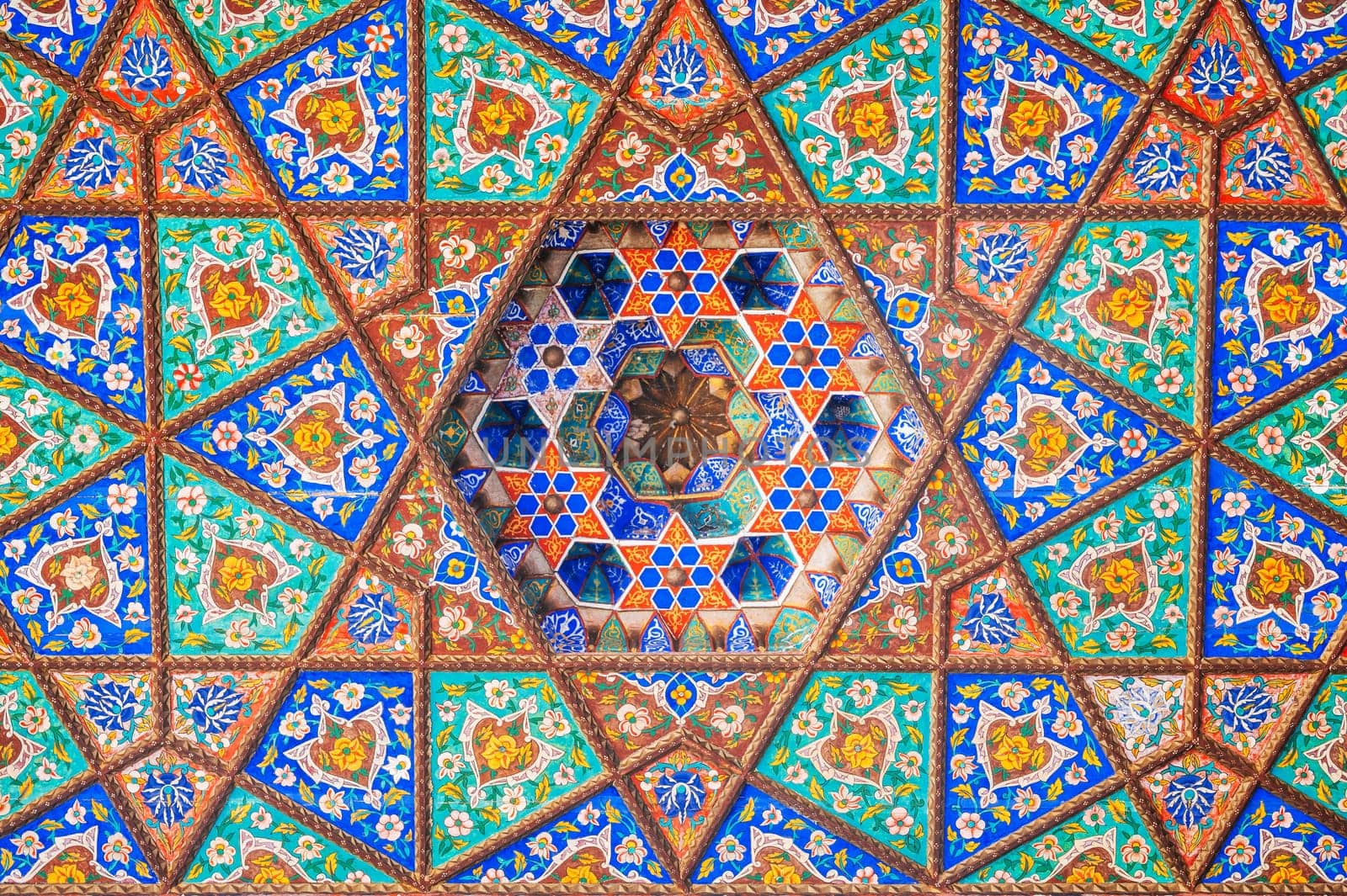 colorful background of carved wooden painted ceiling in the Museum of Art of Uzbekistan with traditional Uzbek ornaments and oriental patterns in Tashkent